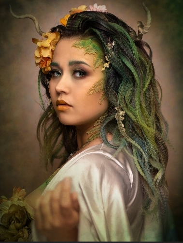 Fantasy portrait with ethereal green hair adorned with golden flowers and glitter in a dreamy forest setting.