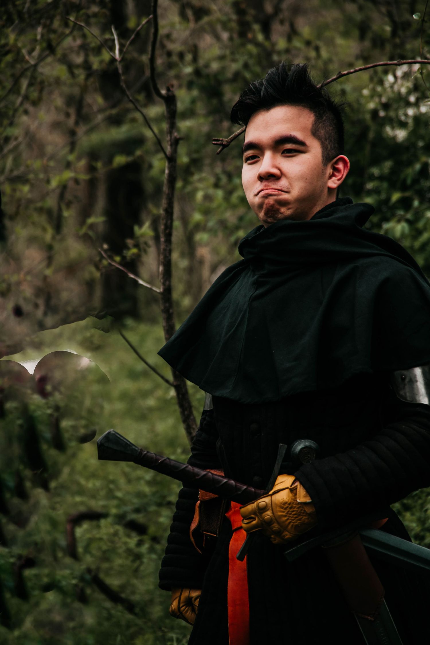 A person in a black hoodie stands against a wooded backdrop in a series of candid outdoor shots.