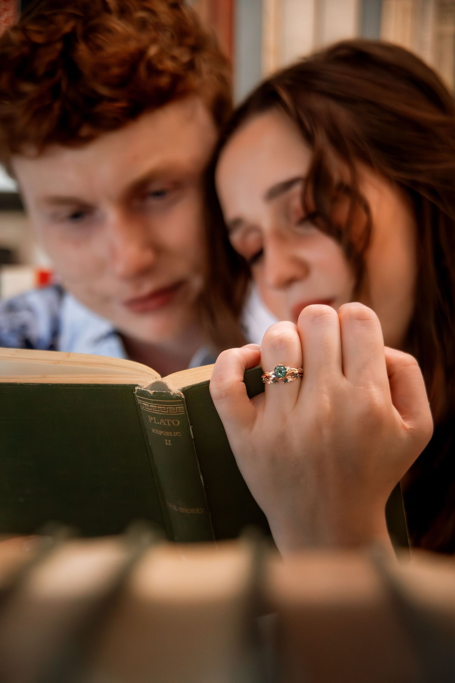 Close-up of hands holding books in a dimly lit setting.