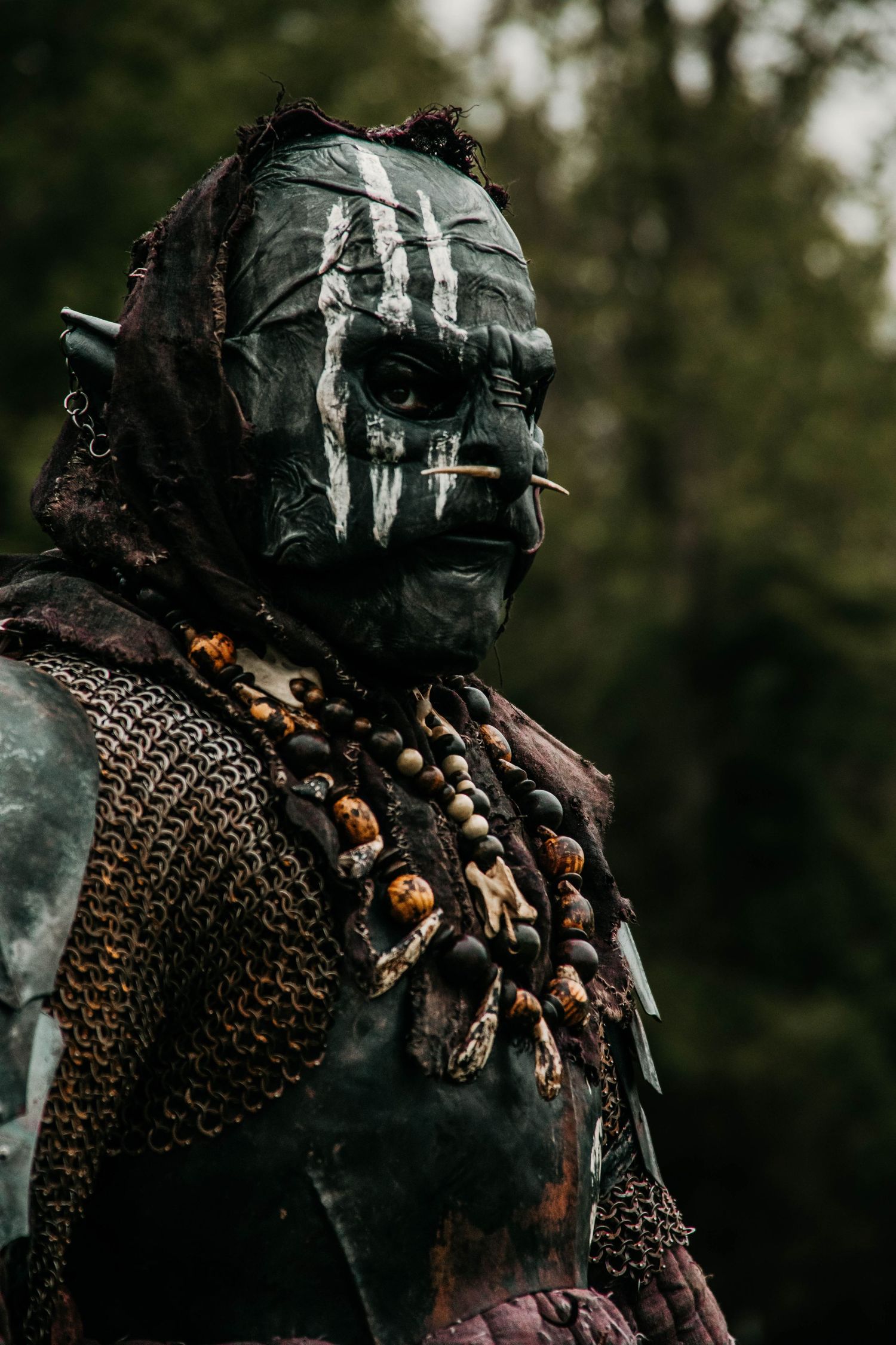 Dark armored costume with chainmail and metallic mask details in dramatic lighting.