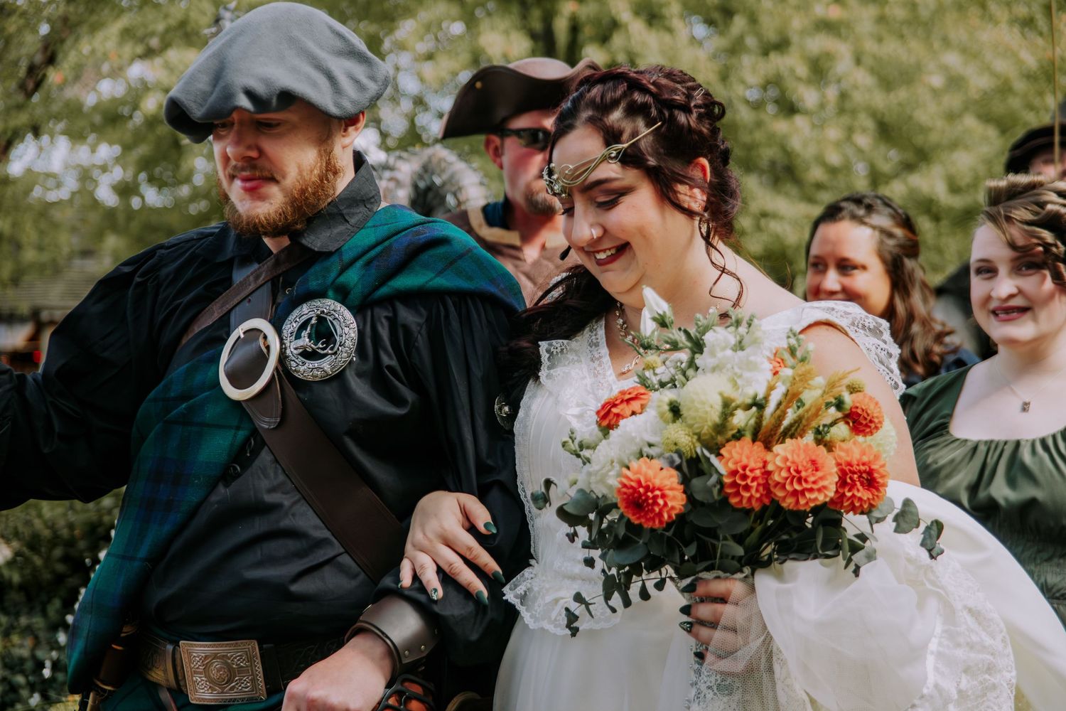Wedding celebration with guests and floral decorations in an outdoor setting.