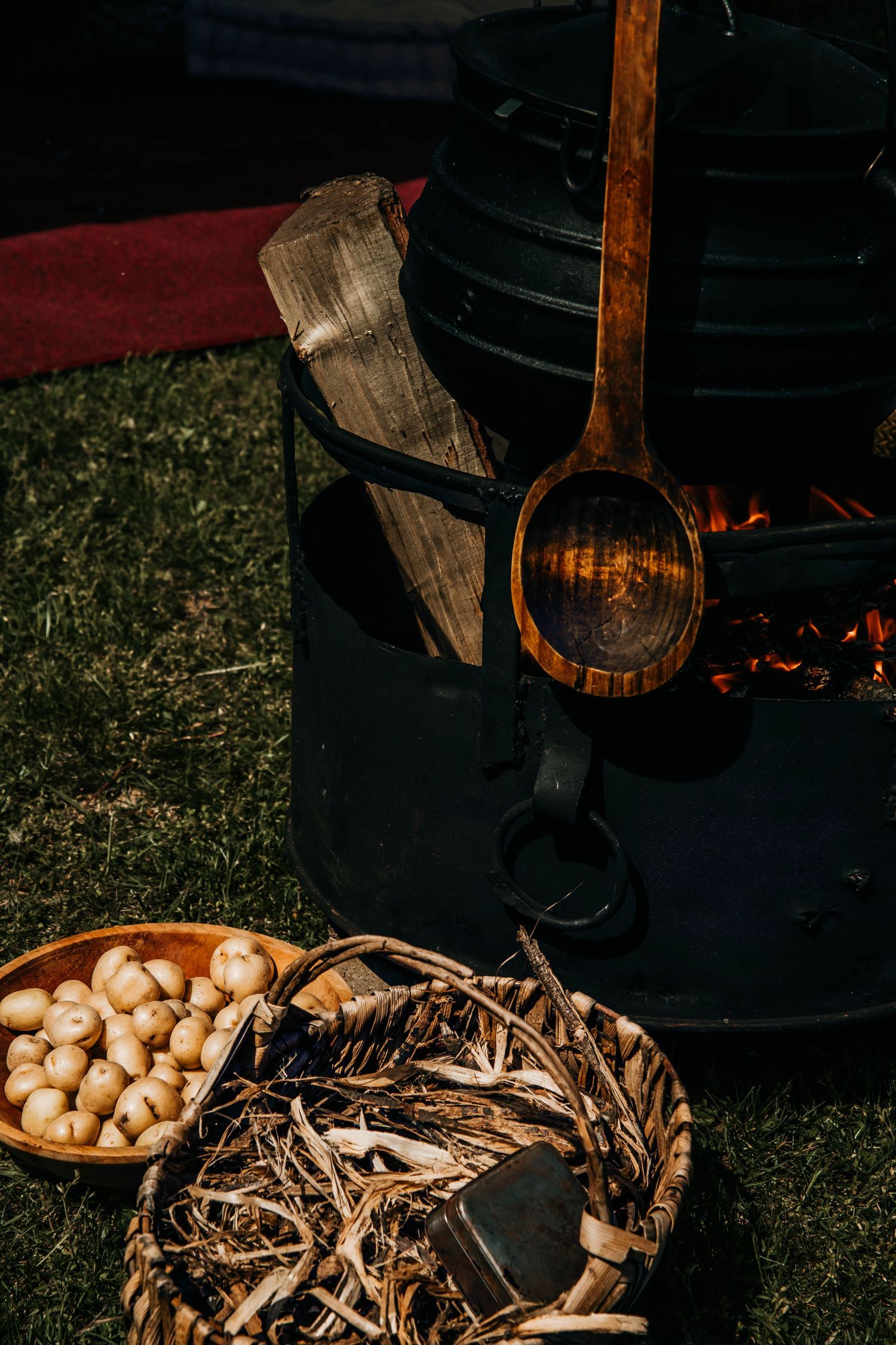 A rustic display of fresh mushrooms and wooden barrels illuminated by warm lighting in a dark outdoor setting.