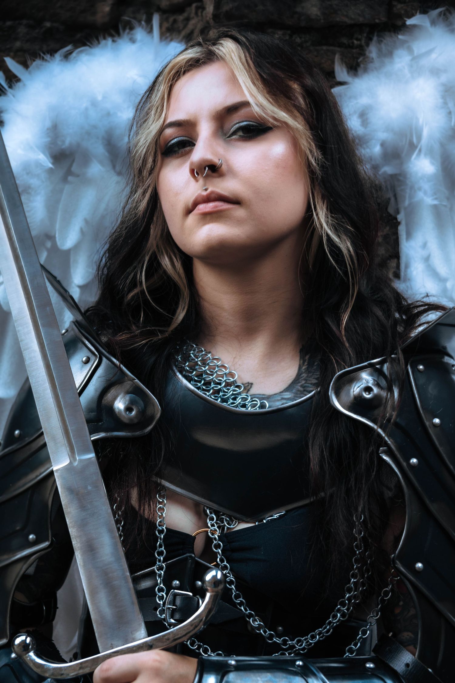 Dark fantasy portrait with smoke effects showing dramatic lighting and silver chain accessories against black background.