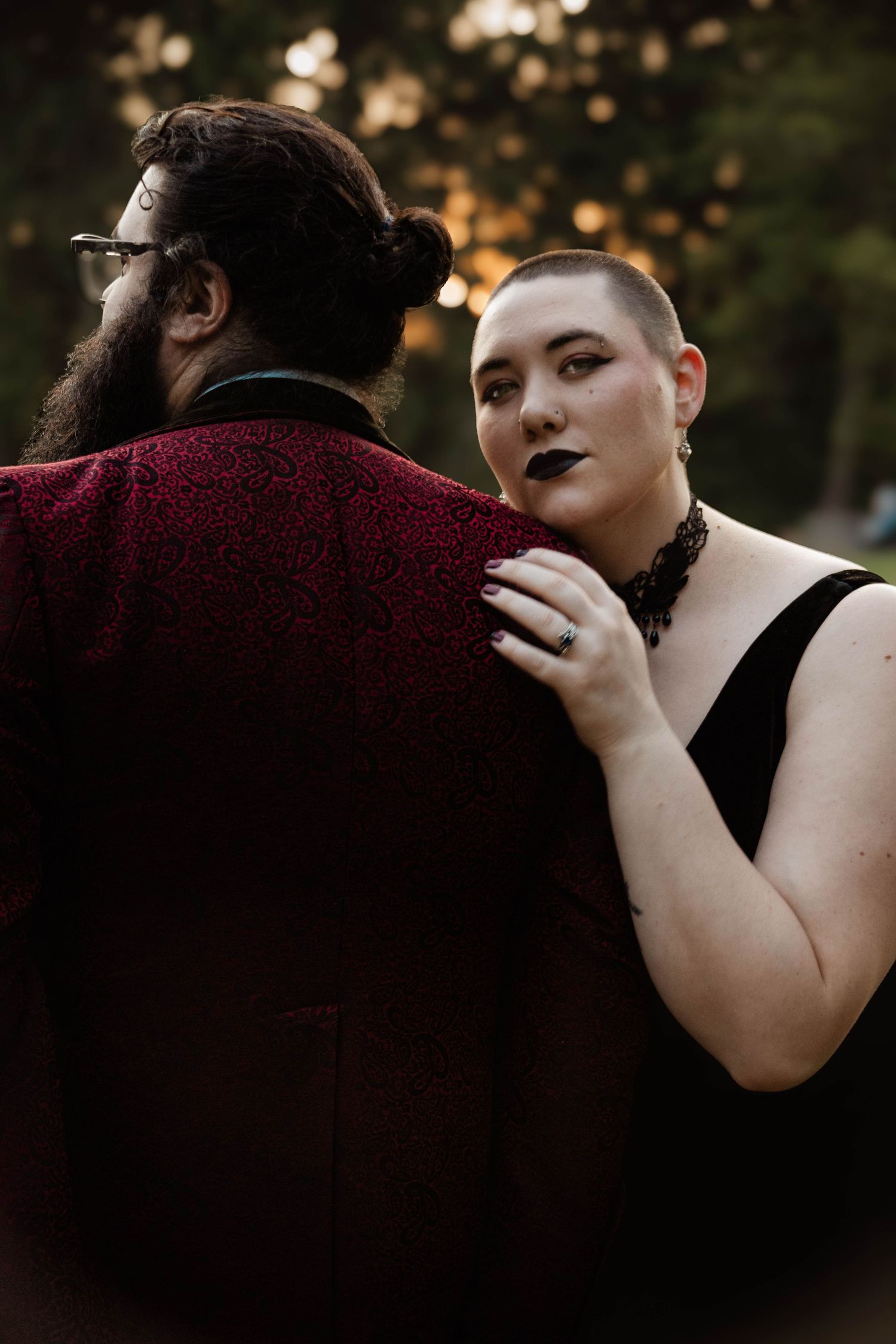 Dramatic portrait series featuring dark lipstick and burgundy clothing against a moody outdoor setting.