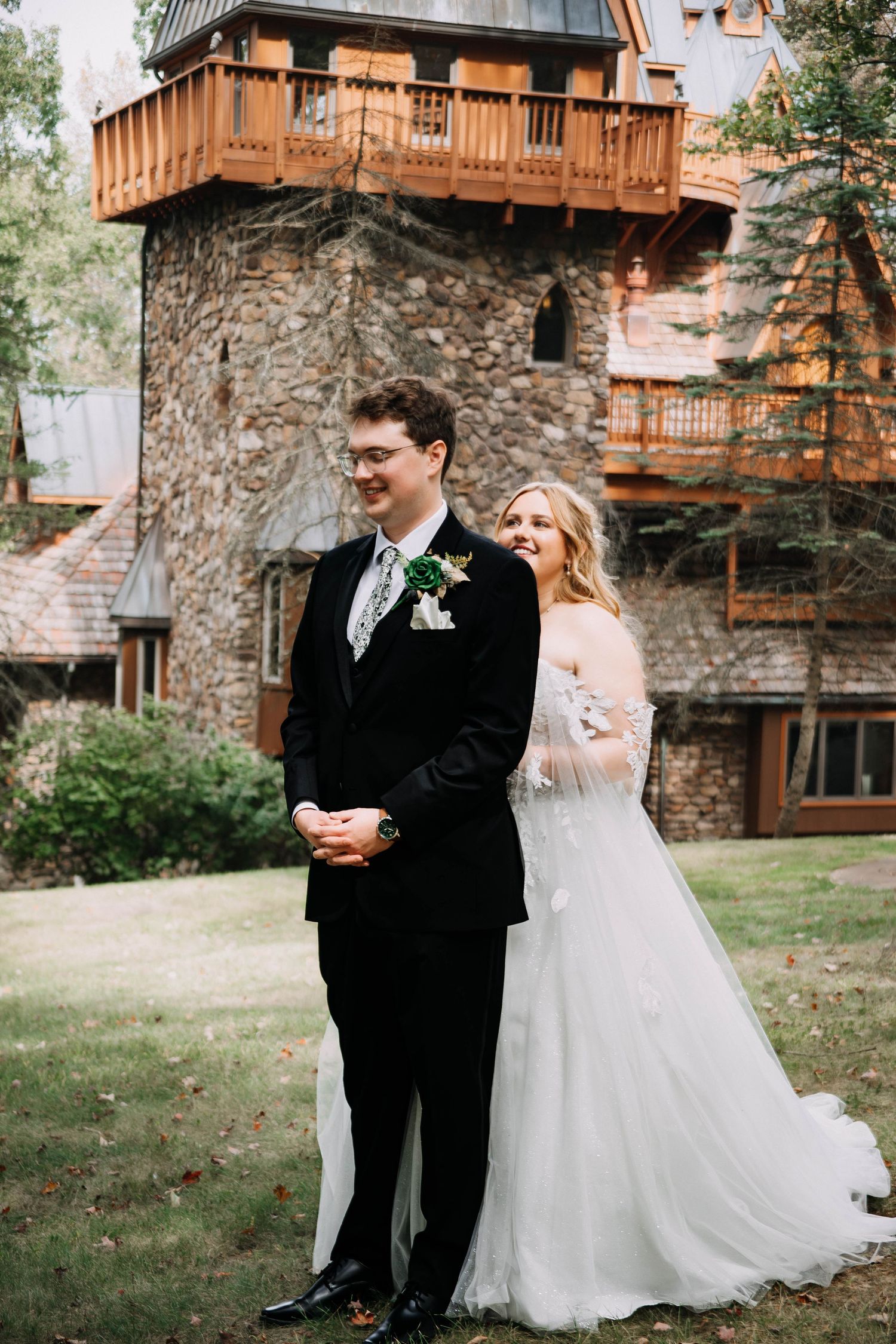 Couple shares romantic moments during their outdoor wedding at a rustic stone venue with wooden balconies.