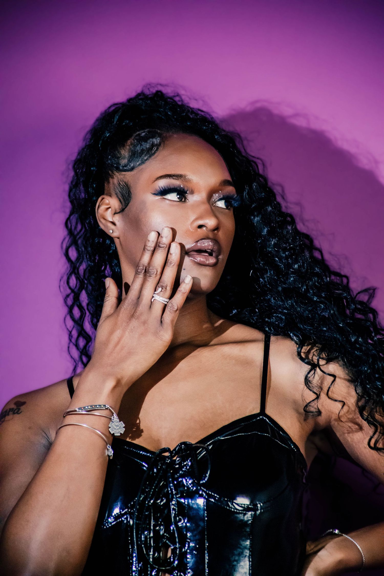 Artistic photo series with purple lighting showing dramatic poses in black sequined clothing.
