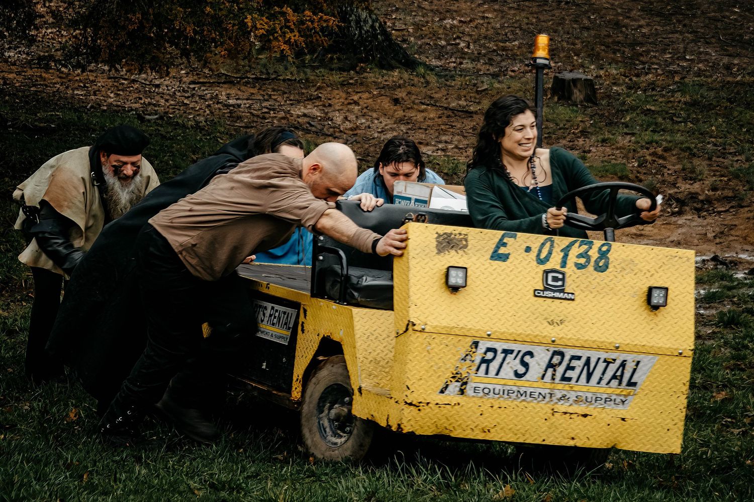 A yellow vintage car is being inspected from various angles in a series of outdoor photographs.