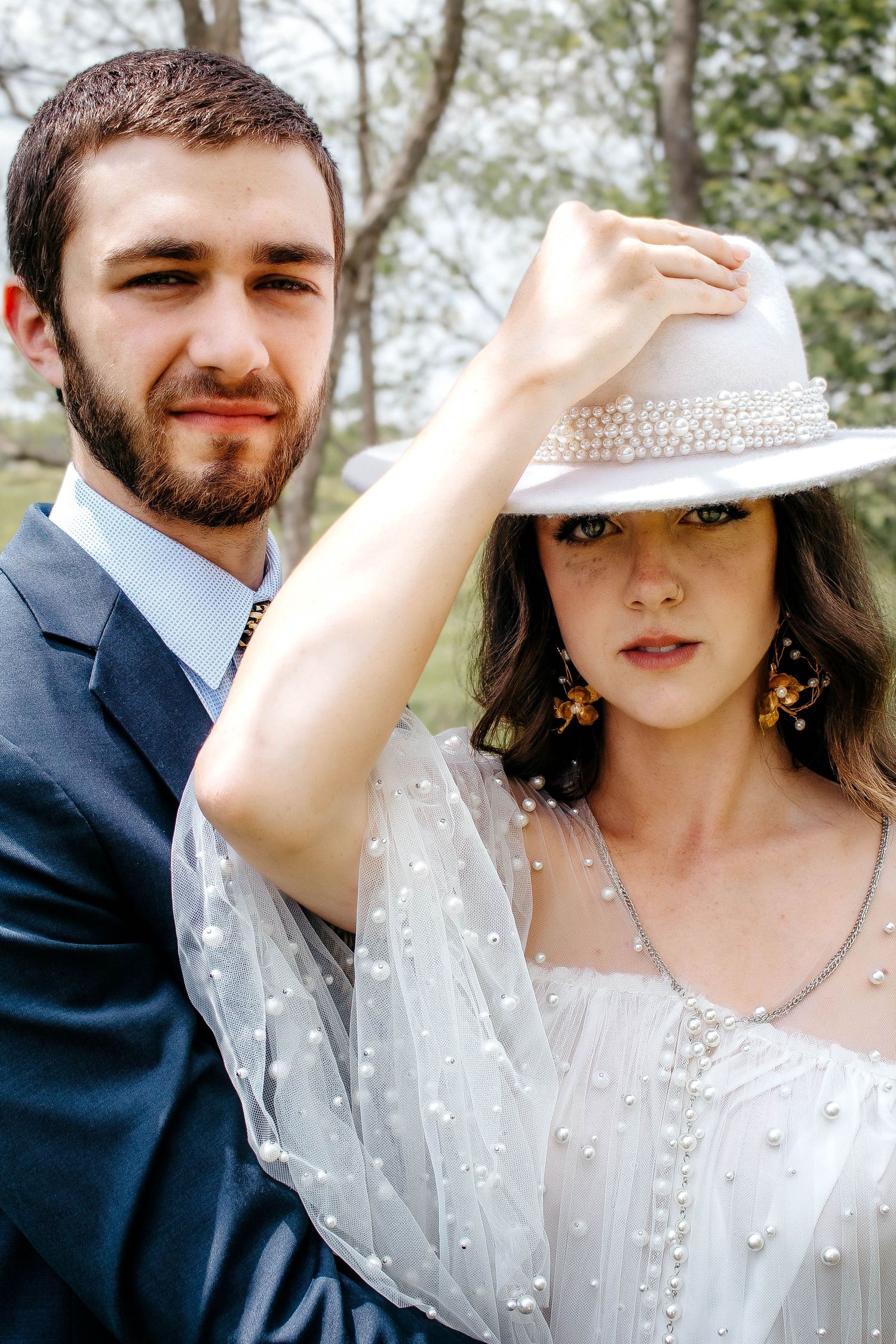 A romantic wedding photo collage showing close-up shots of a couple in formal attire with a white dress and navy suit.