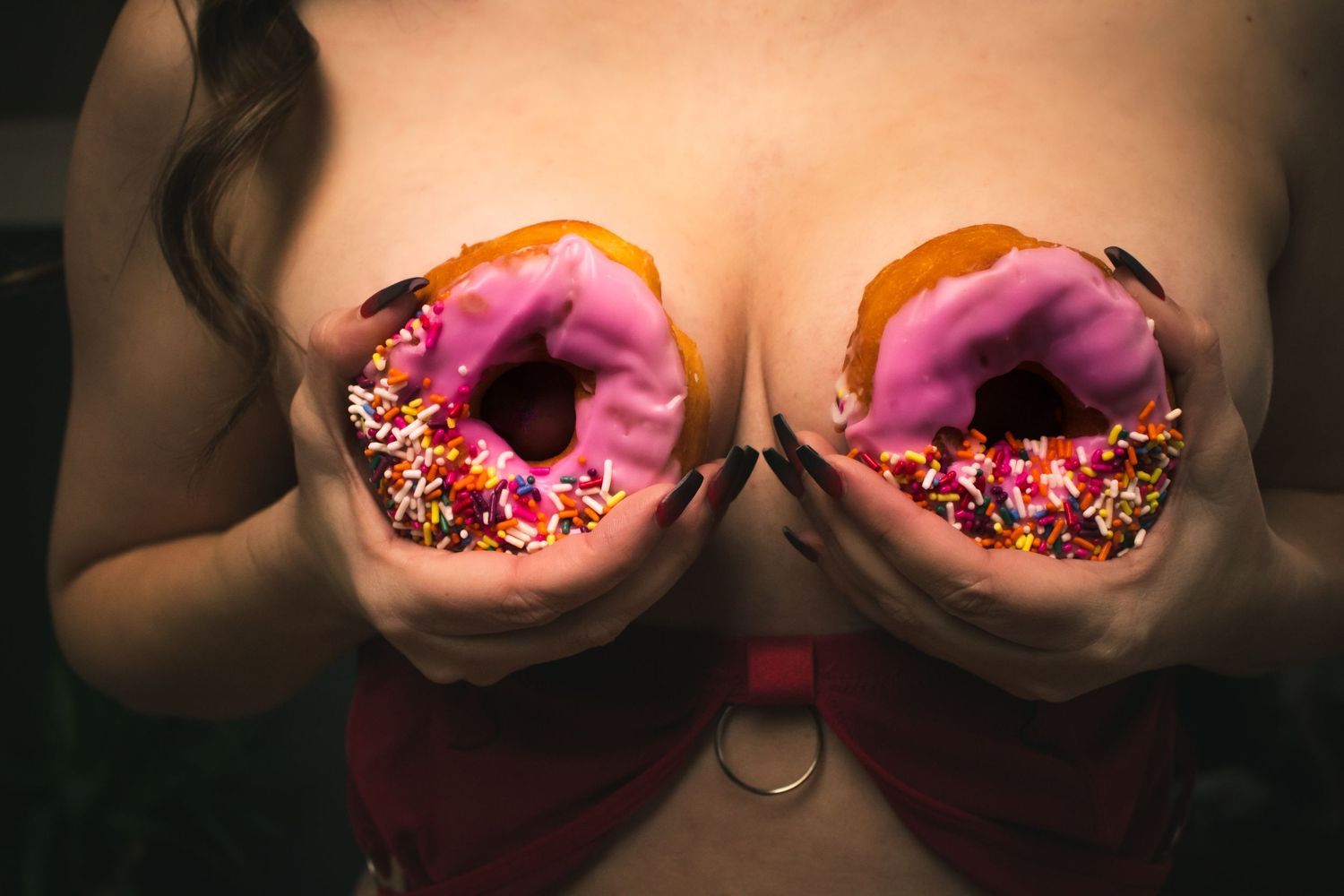 Close-up of decorative pink and red cupcake frosting with colorful sprinkles.