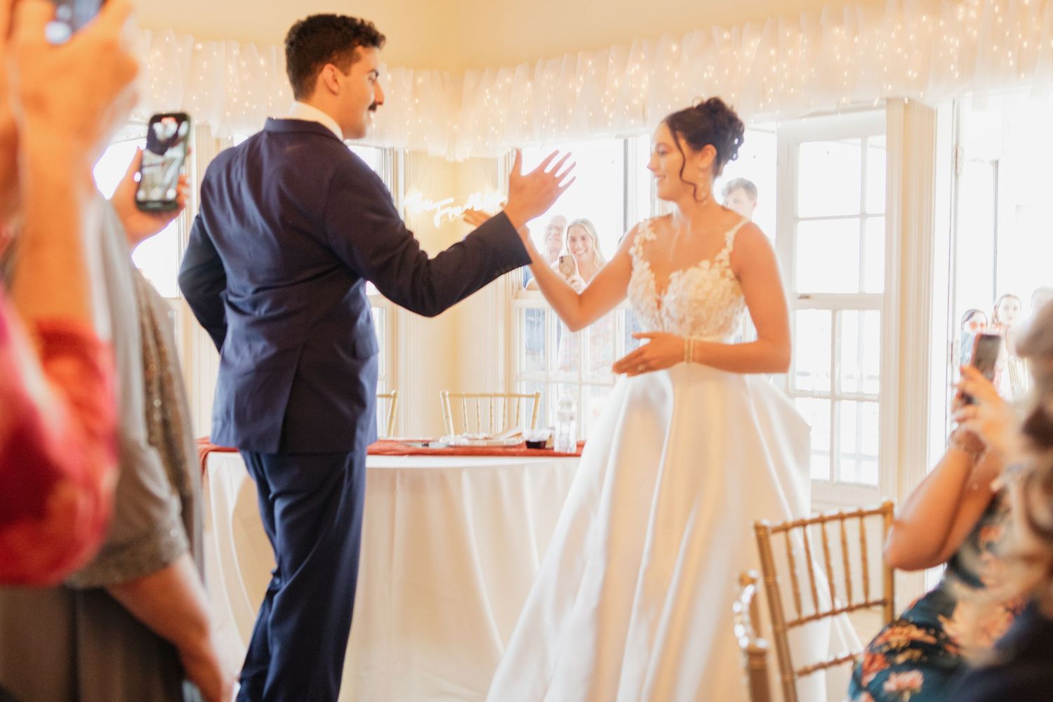 Elegant wedding reception scene with string lights and natural window lighting.