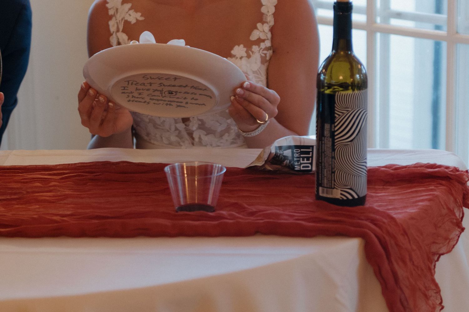 Wedding reception table set with plates, wine glasses and decorative details.