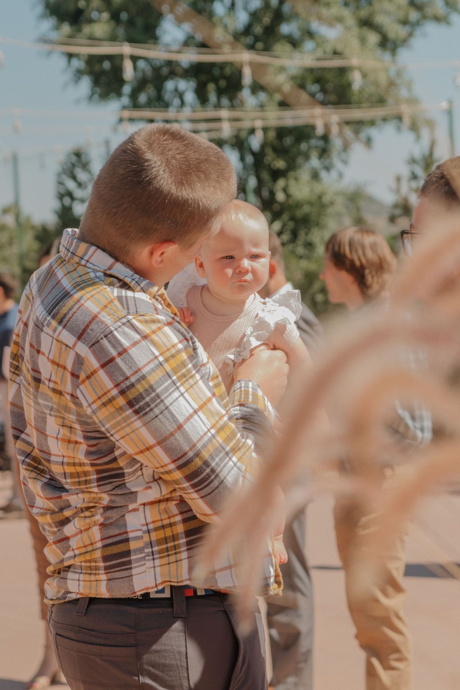 A series of images showing guests hugging and embracing at a joyful outdoor celebration.