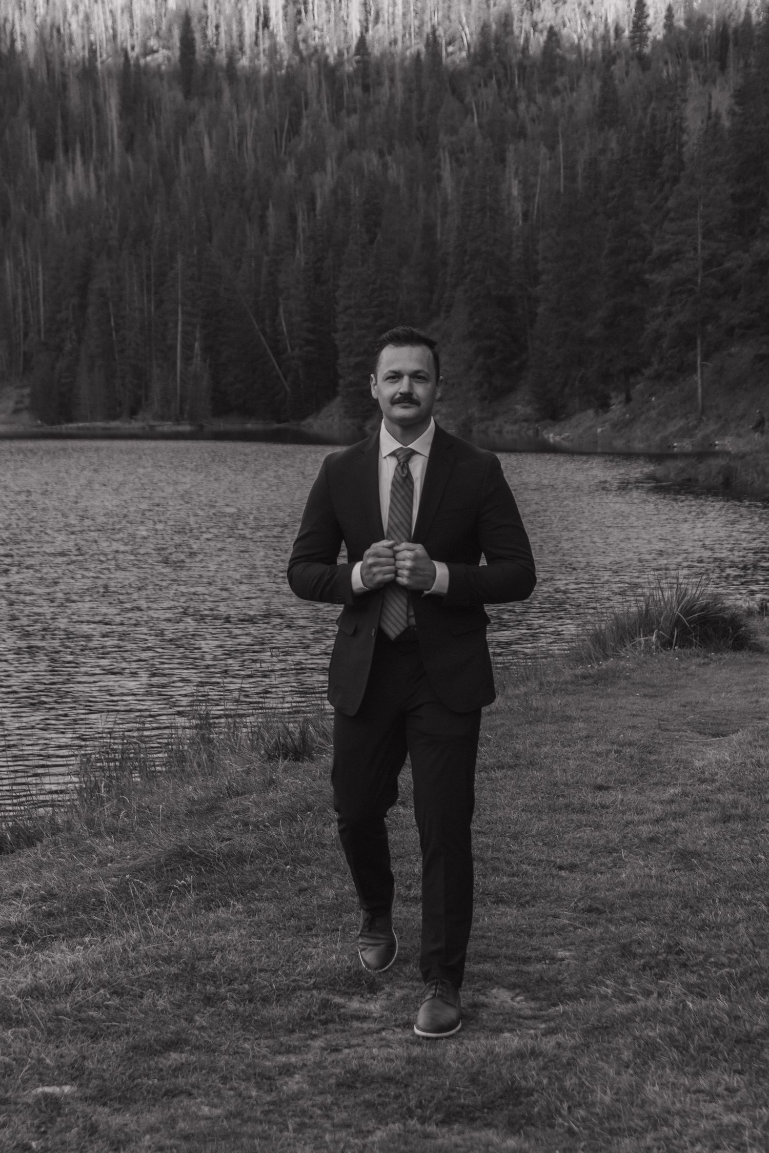 Black and white photos showing joyful moments by a lake surrounded by evergreen trees.