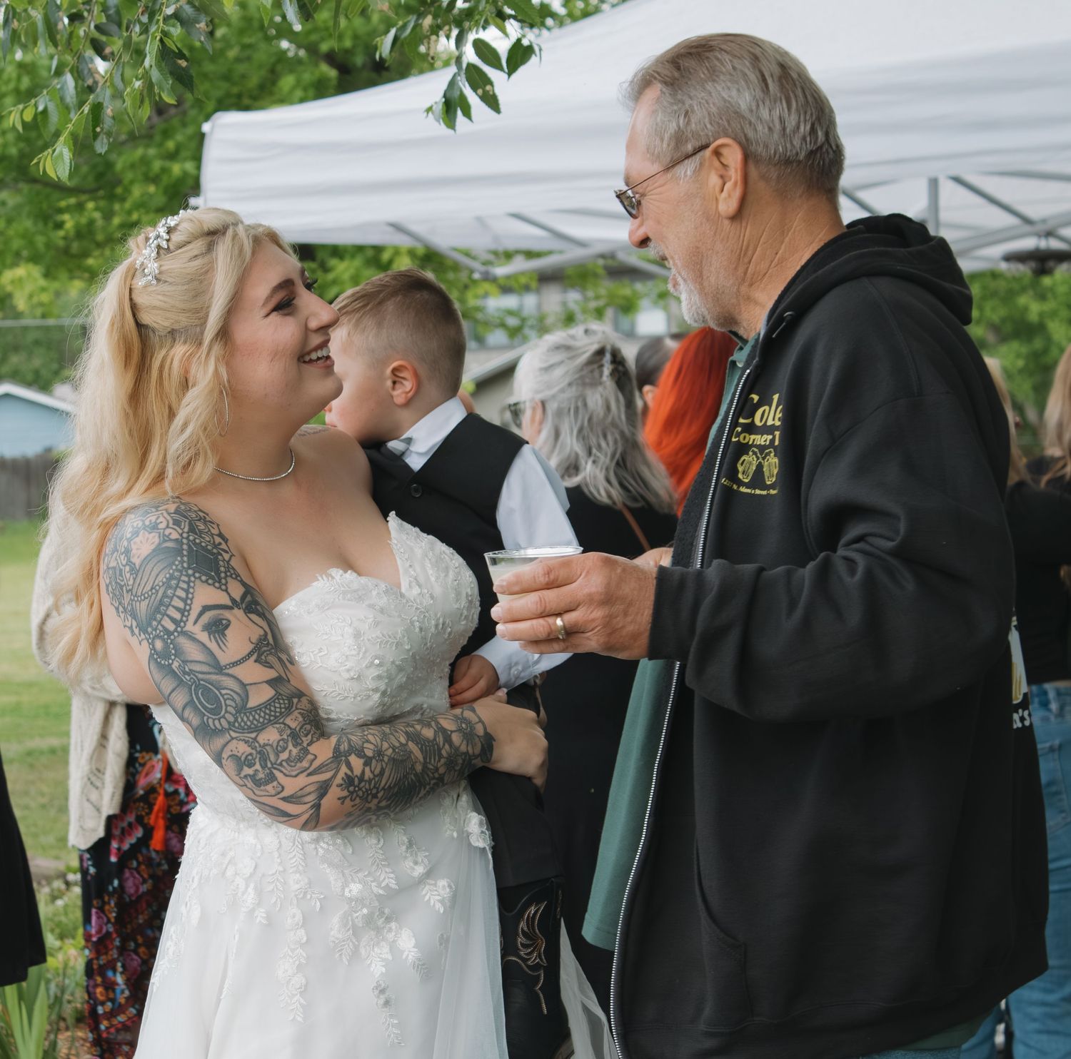Wedding guests share a joyful moment during an outdoor reception.