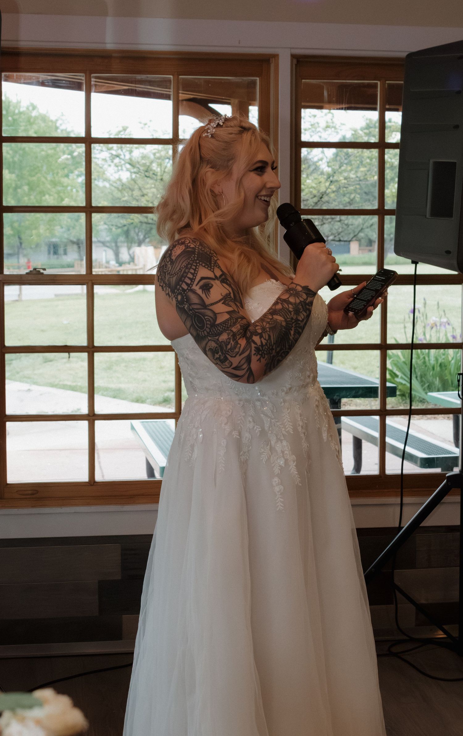 Wedding venue interior with large windows overlooking green scenery.