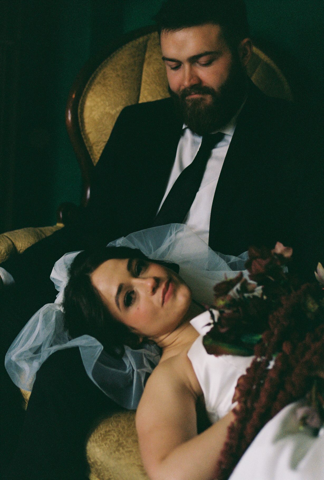 An intimate moment captured in moody lighting on vintage furniture.
