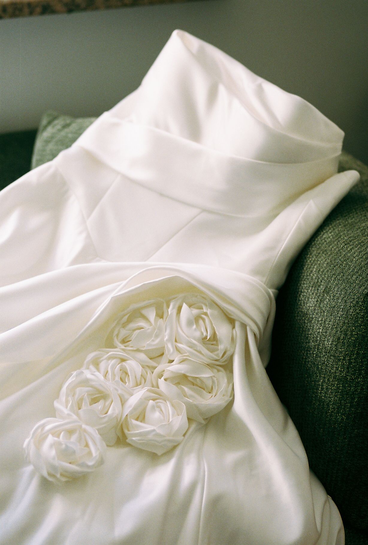 Close-up of white wedding dress bodice with intricate rose details.