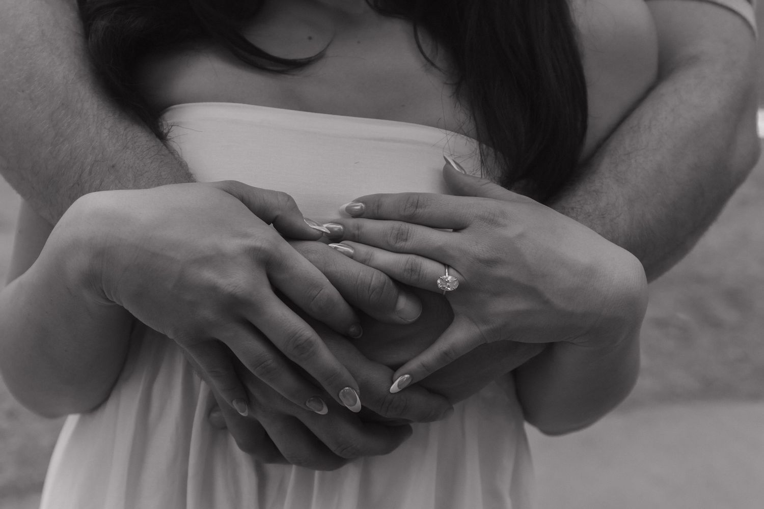 Close-up shot of hands tenderly intertwined against a soft, blurred background.
