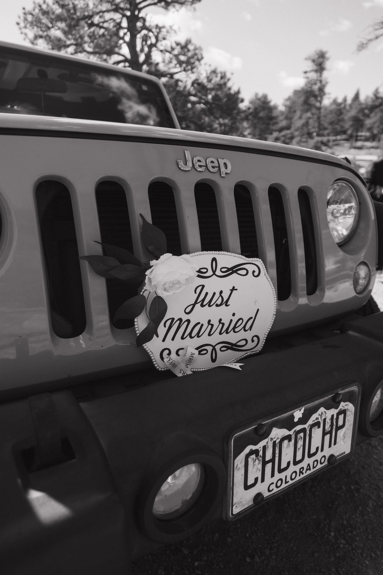 Jeep Wrangler with Just Married sign and Colorado license plate in black and white photo.