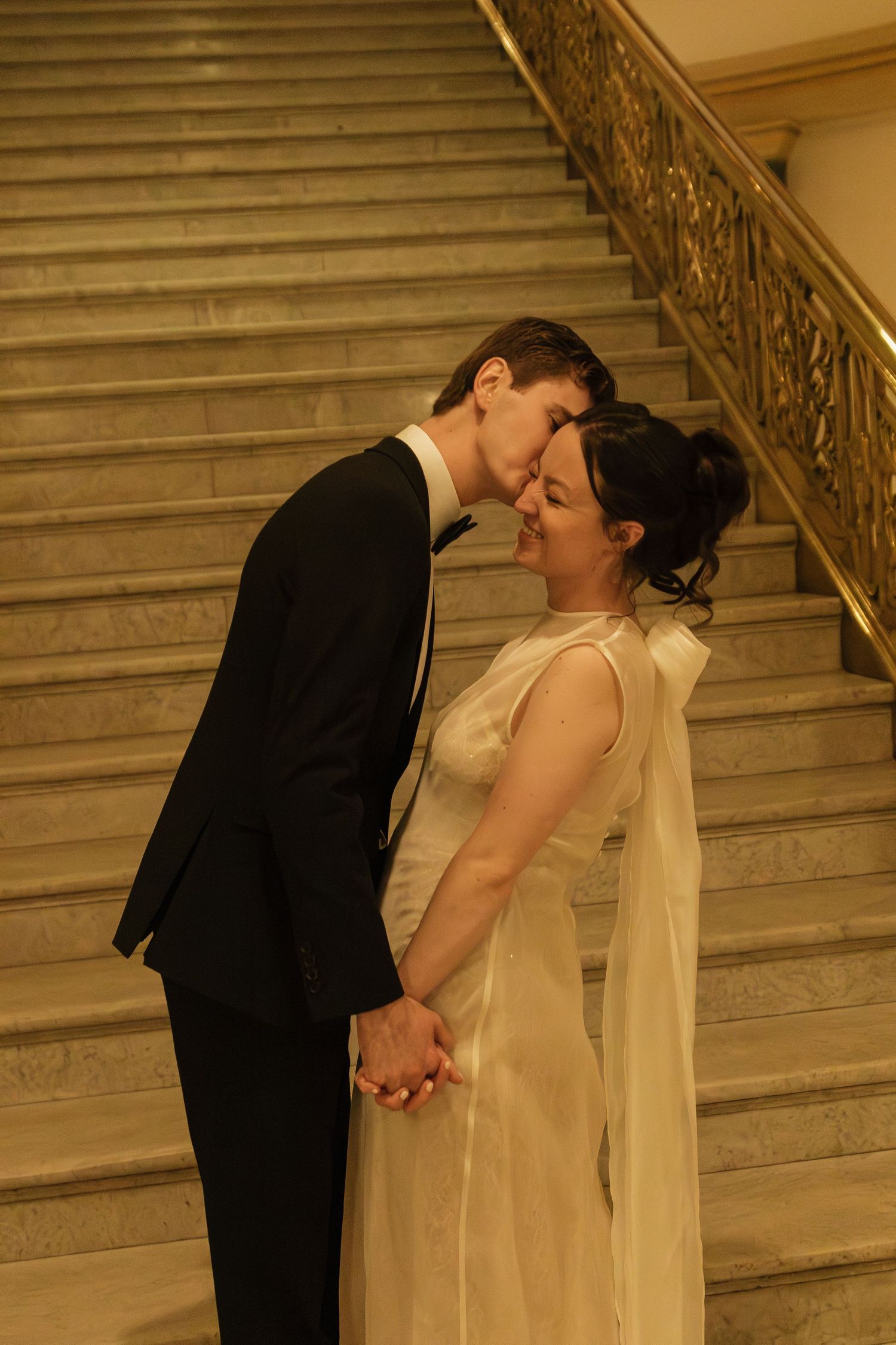 Romantic couple sharing a tender moment on an elegant staircase.