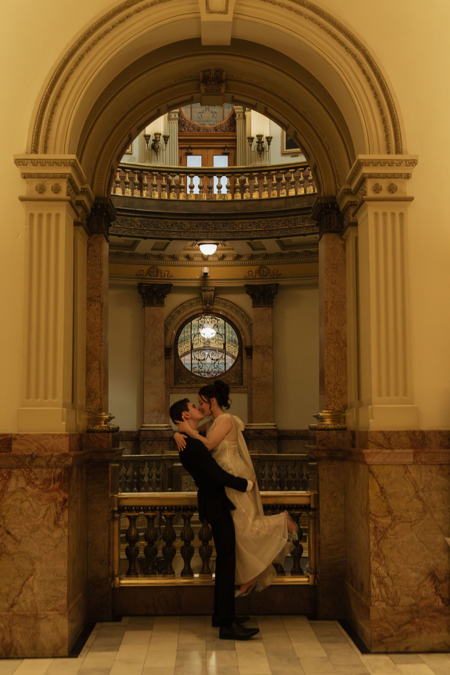 An elegant marble hallway with arched ceilings and ornate architectural details during a wedding ceremony.