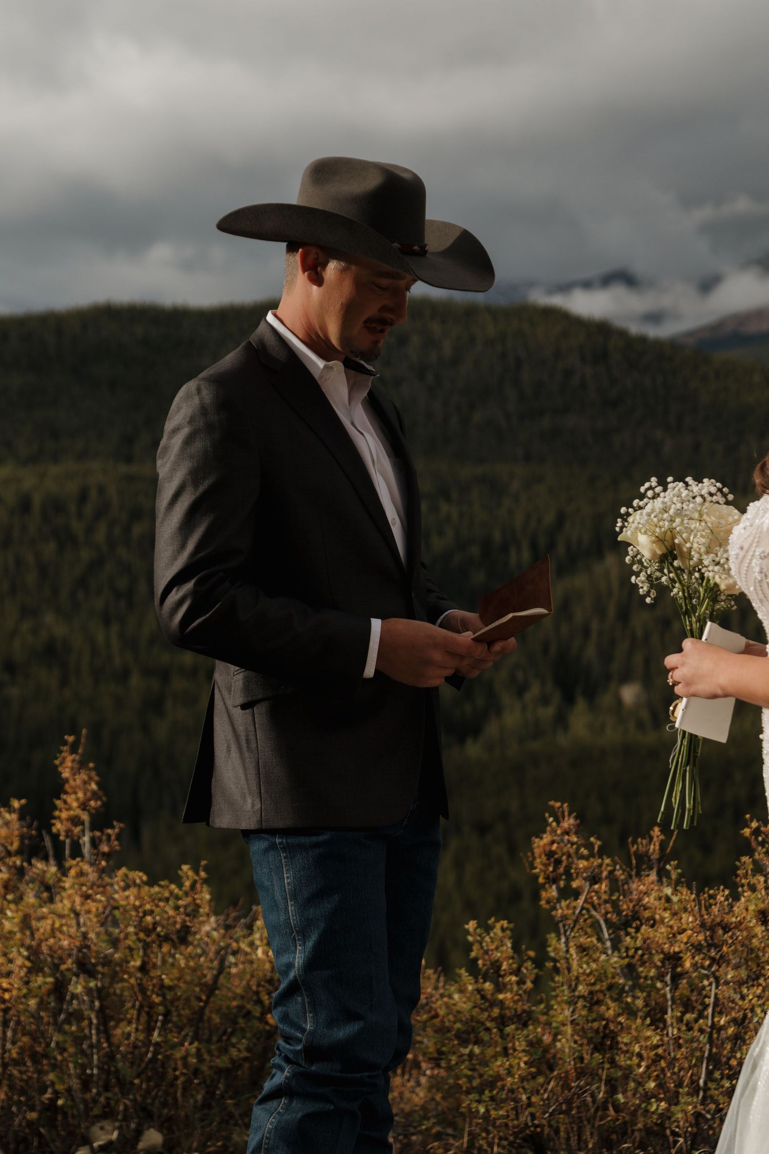 A western-themed wedding scene with mountain vistas and autumn foliage in the background.