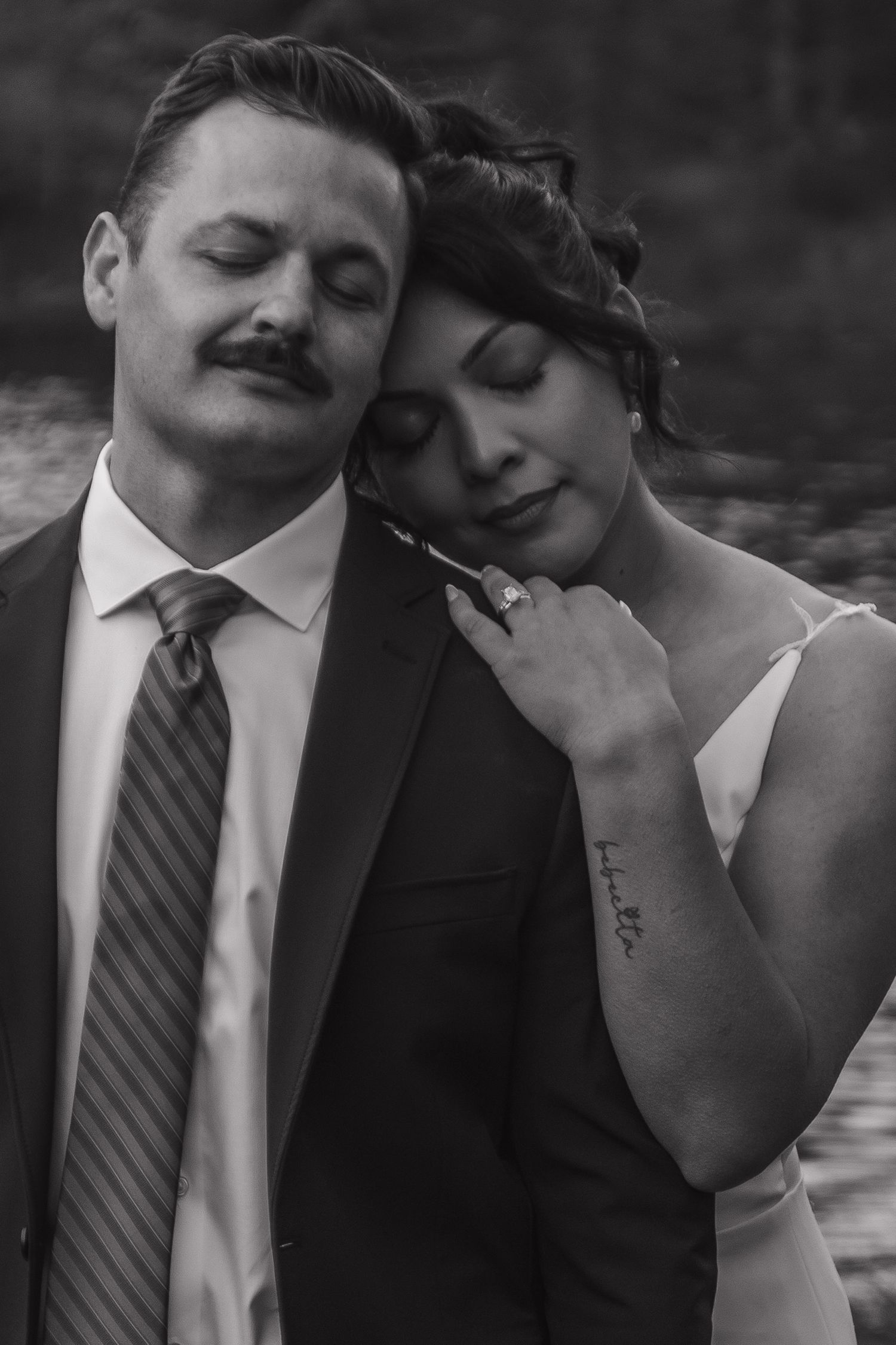Intimate black and white portrait of newlyweds sharing tender moment.