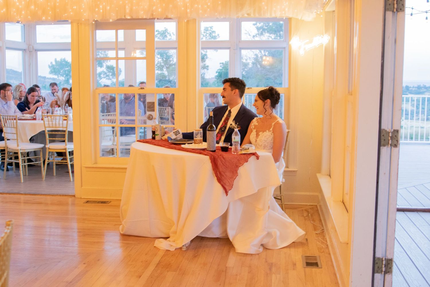 Bright indoor wedding venue with white walls and warm lighting seen through windowpanes.