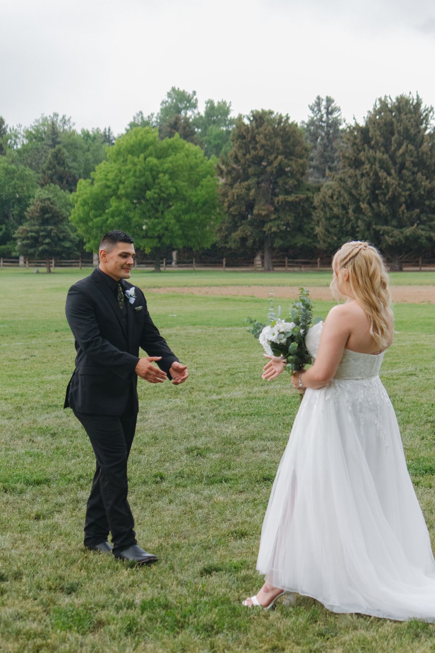 A playful wedding photo shoot with a couple sharing a candid moment in a park setting.