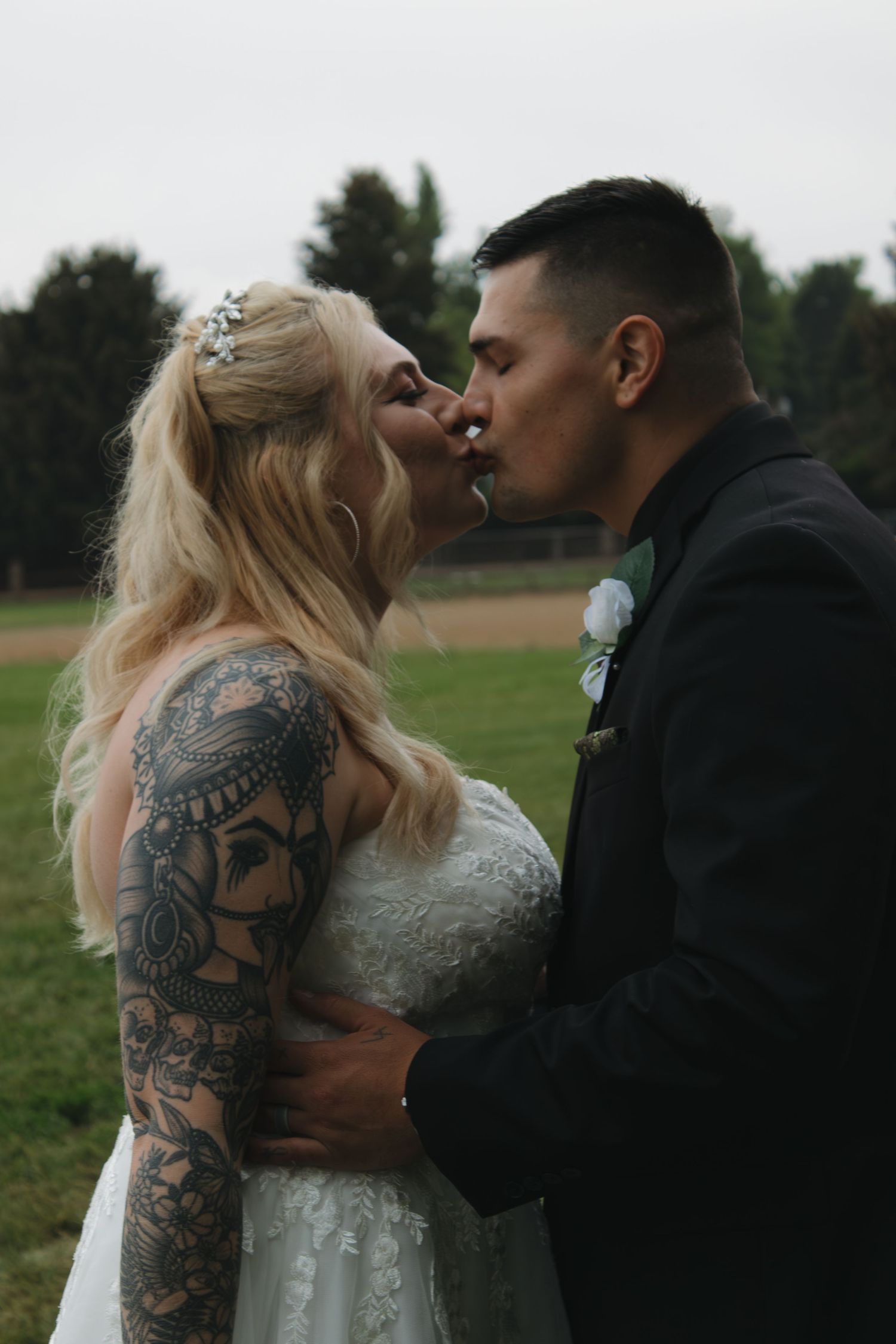 A tender kiss between newlyweds in a beautiful outdoor wedding setting.