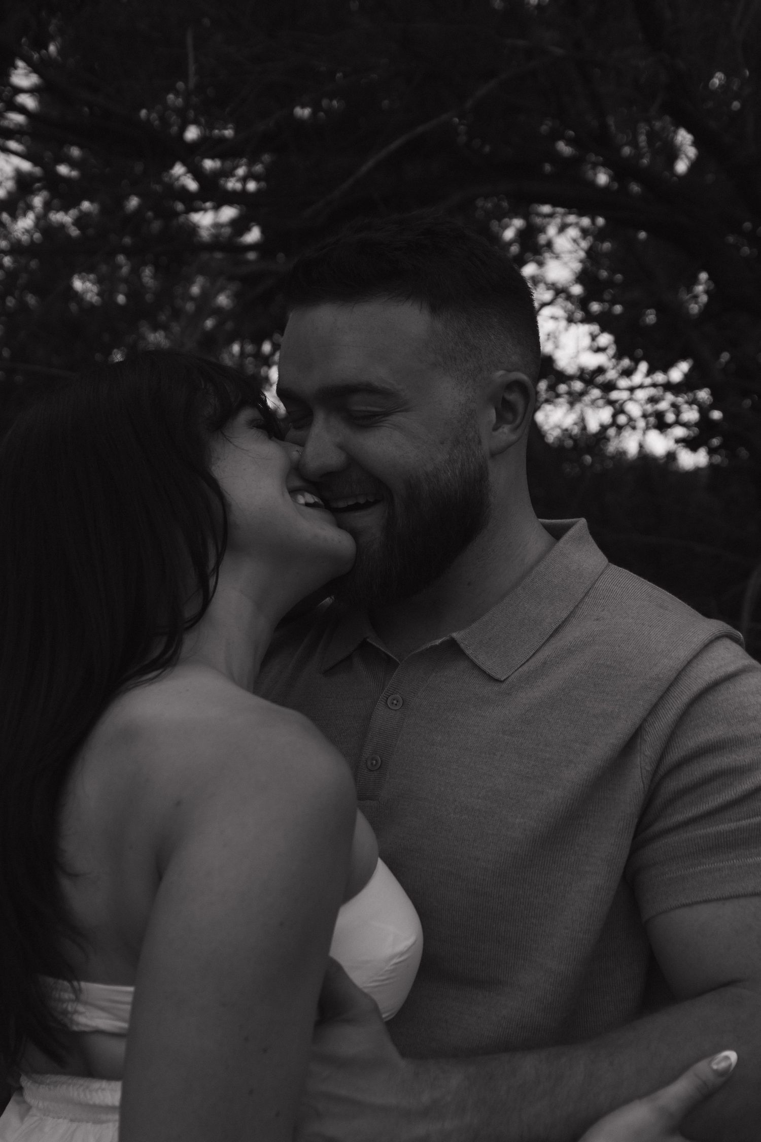 An intimate black and white photograph showing tender affection between two people.