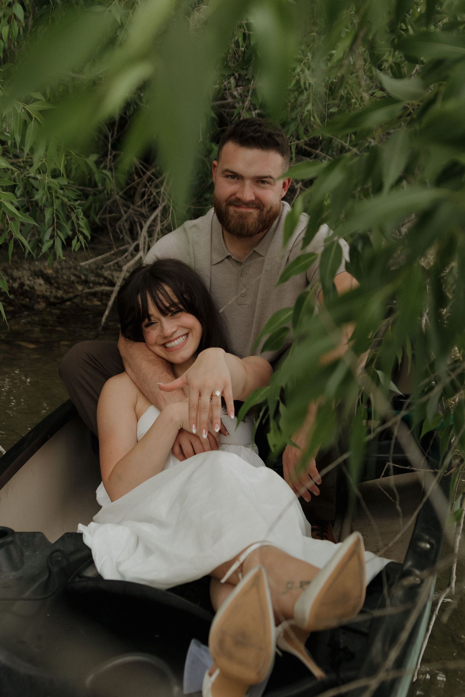 A sweet moment shared outdoors surrounded by green leaves and natural light.