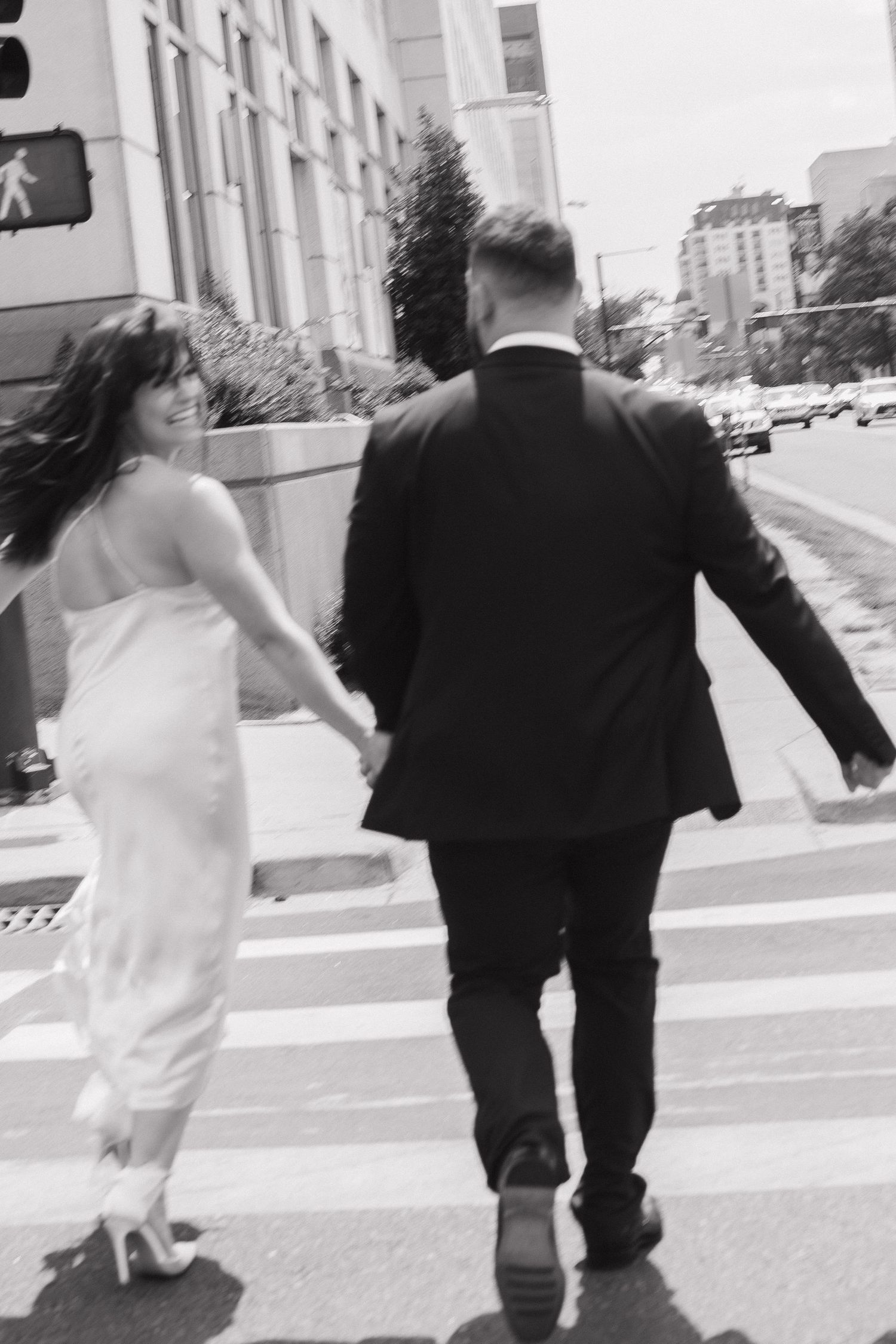 A sequence of black and white photos shows a couple in wedding attire running together down a city street.