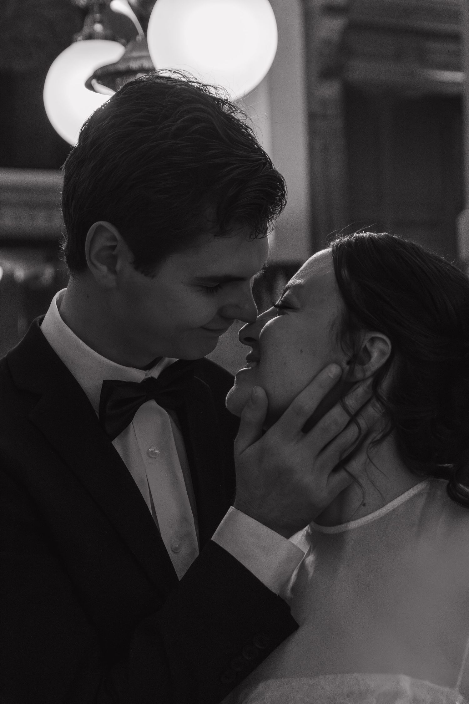 Intimate black and white portrait of newlyweds sharing a romantic kiss.