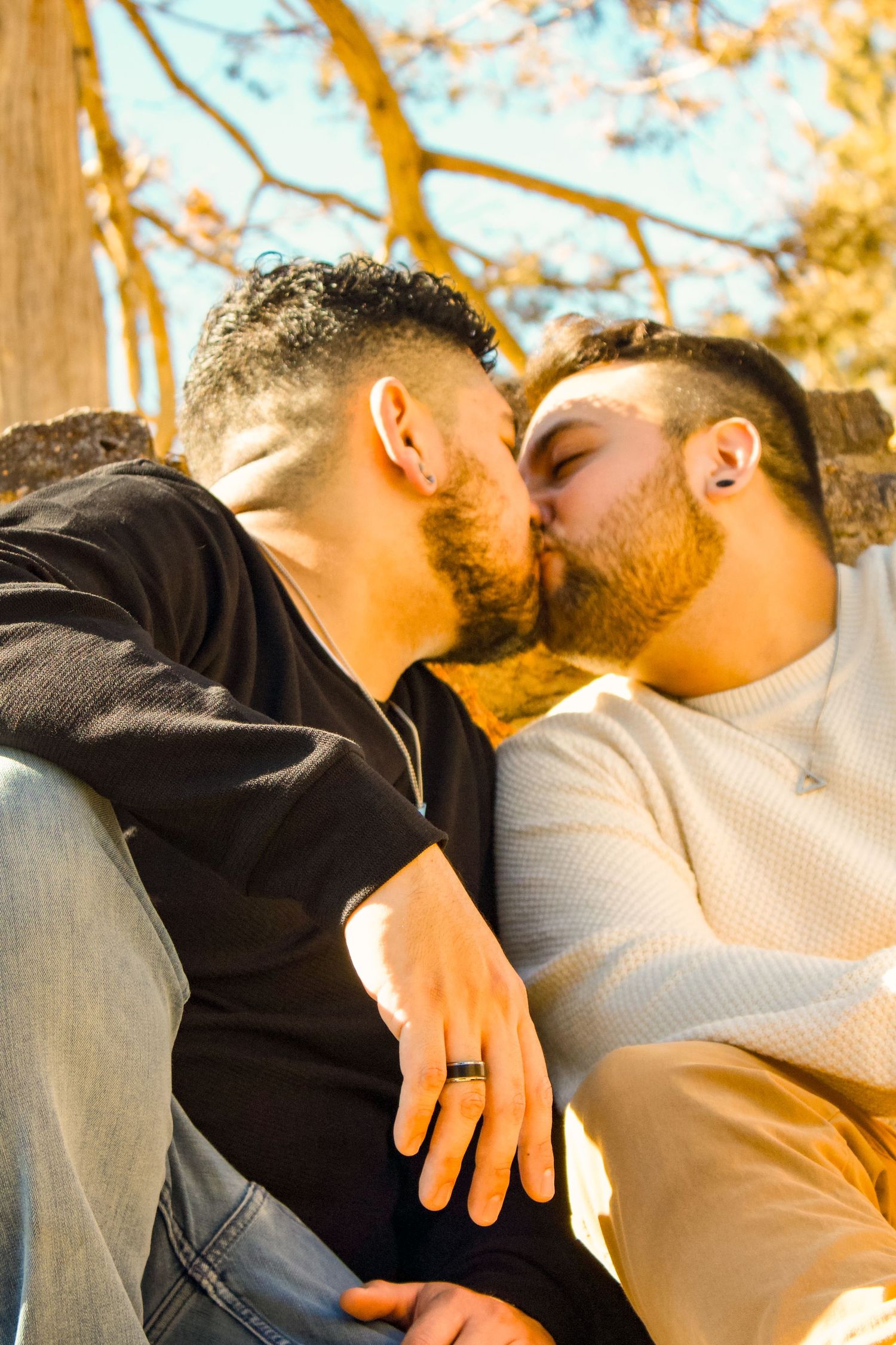 Two figures embrace tenderly during a sunset amongst autumn trees.
