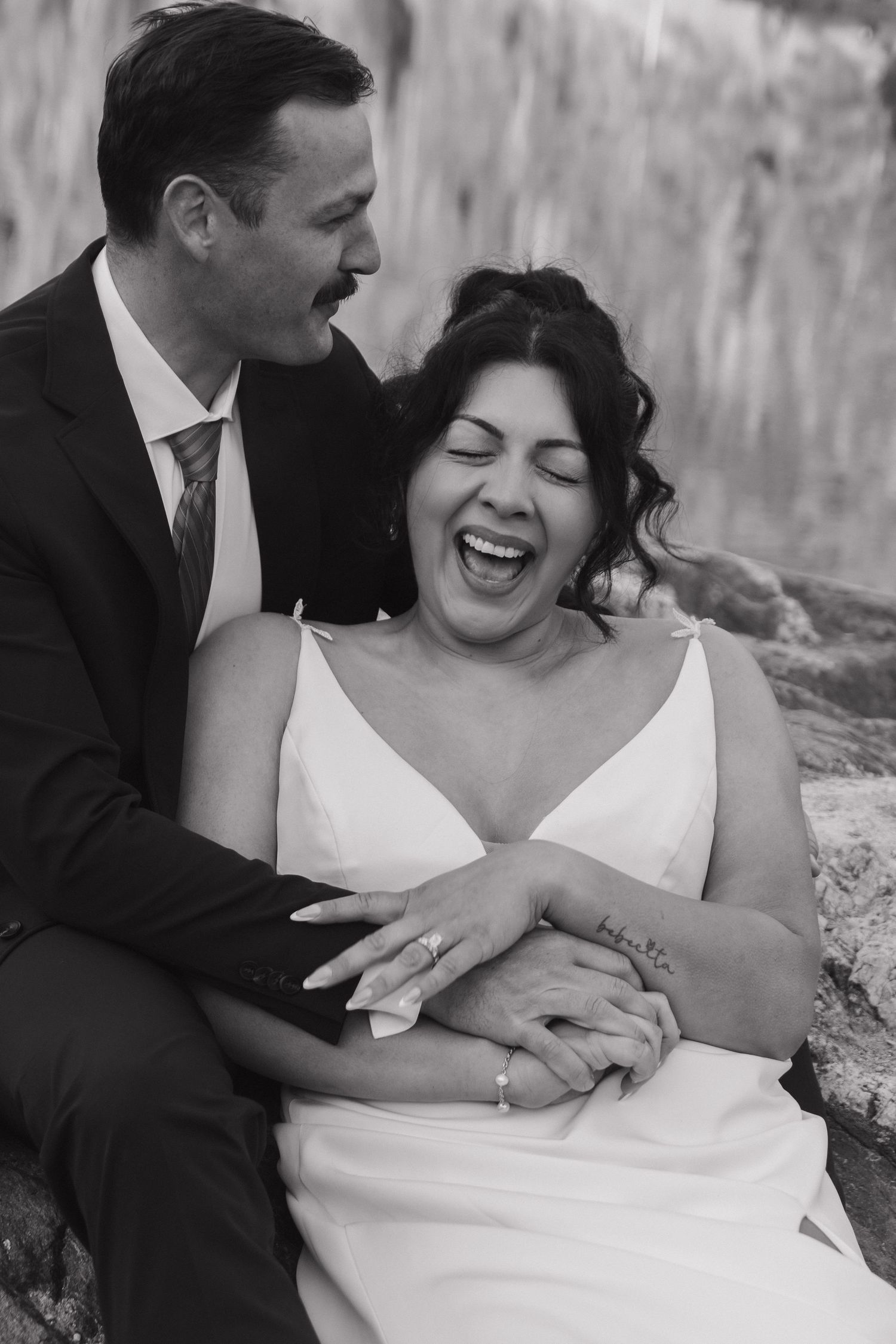 A tender candid moment shared between newlyweds showing natural laughter and joy.