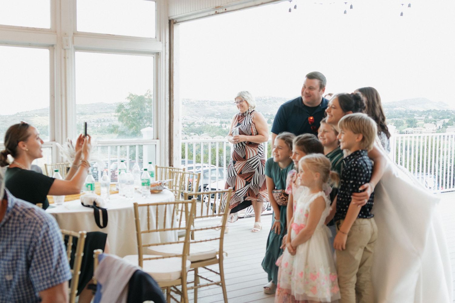 Wedding celebration scene in bright indoor venue with window views.