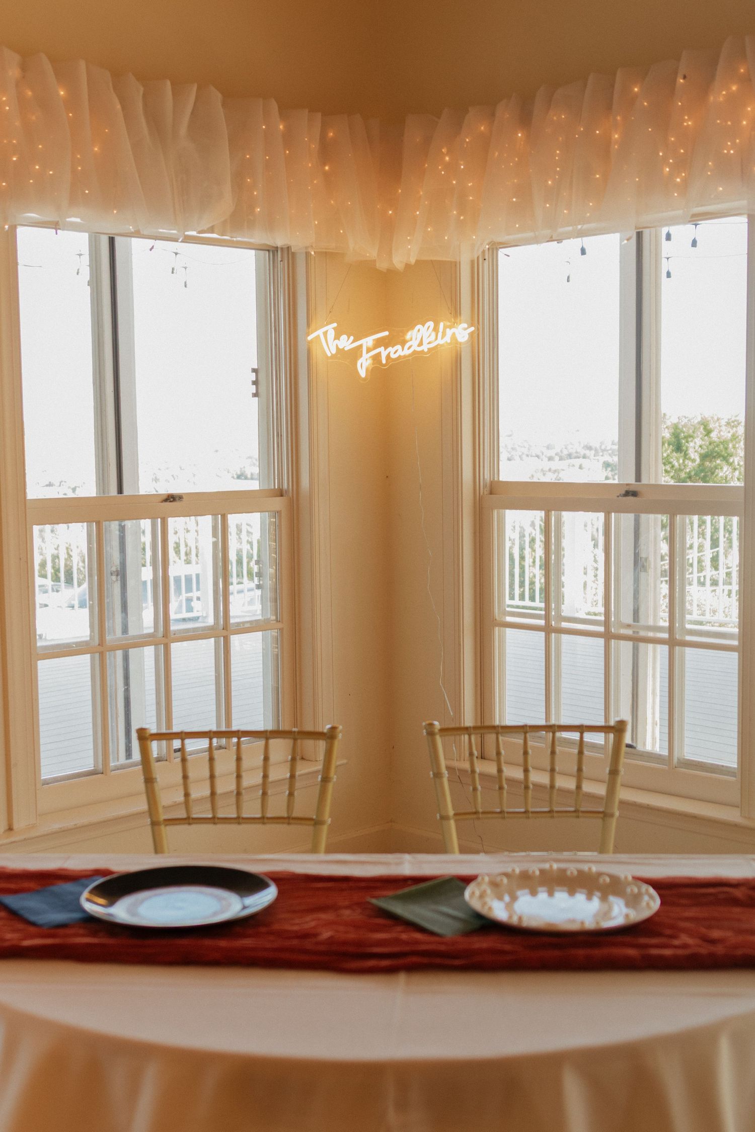 Elegant reception room with string lights and sheer curtains creating warm ambient lighting.