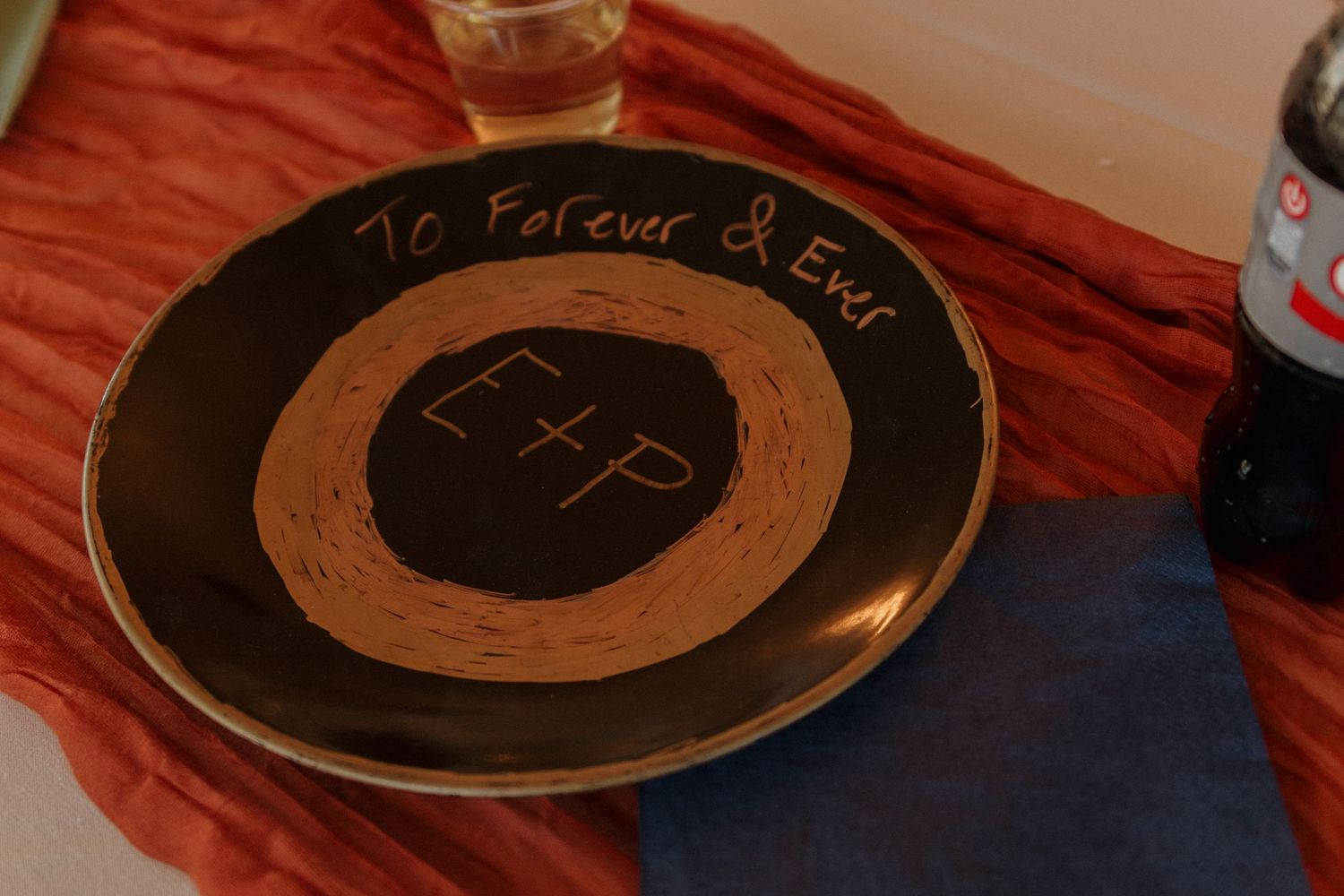 Close-up of decorative gold plates with text on dark wooden surface.