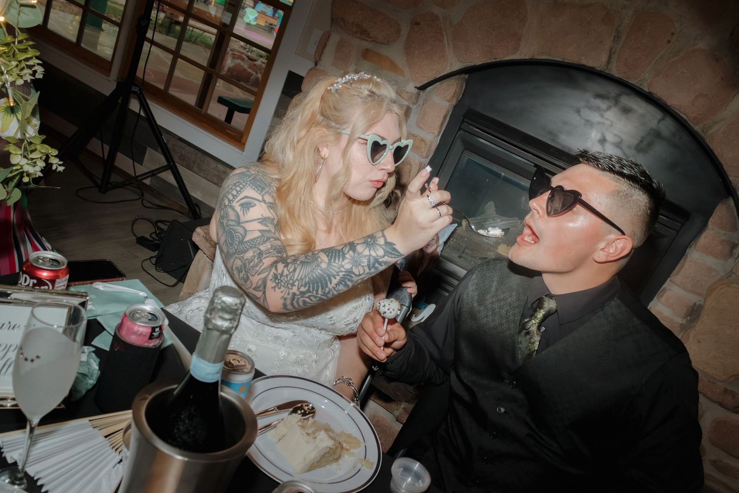 Dark-toned wedding reception photos showing moments of cake sharing.