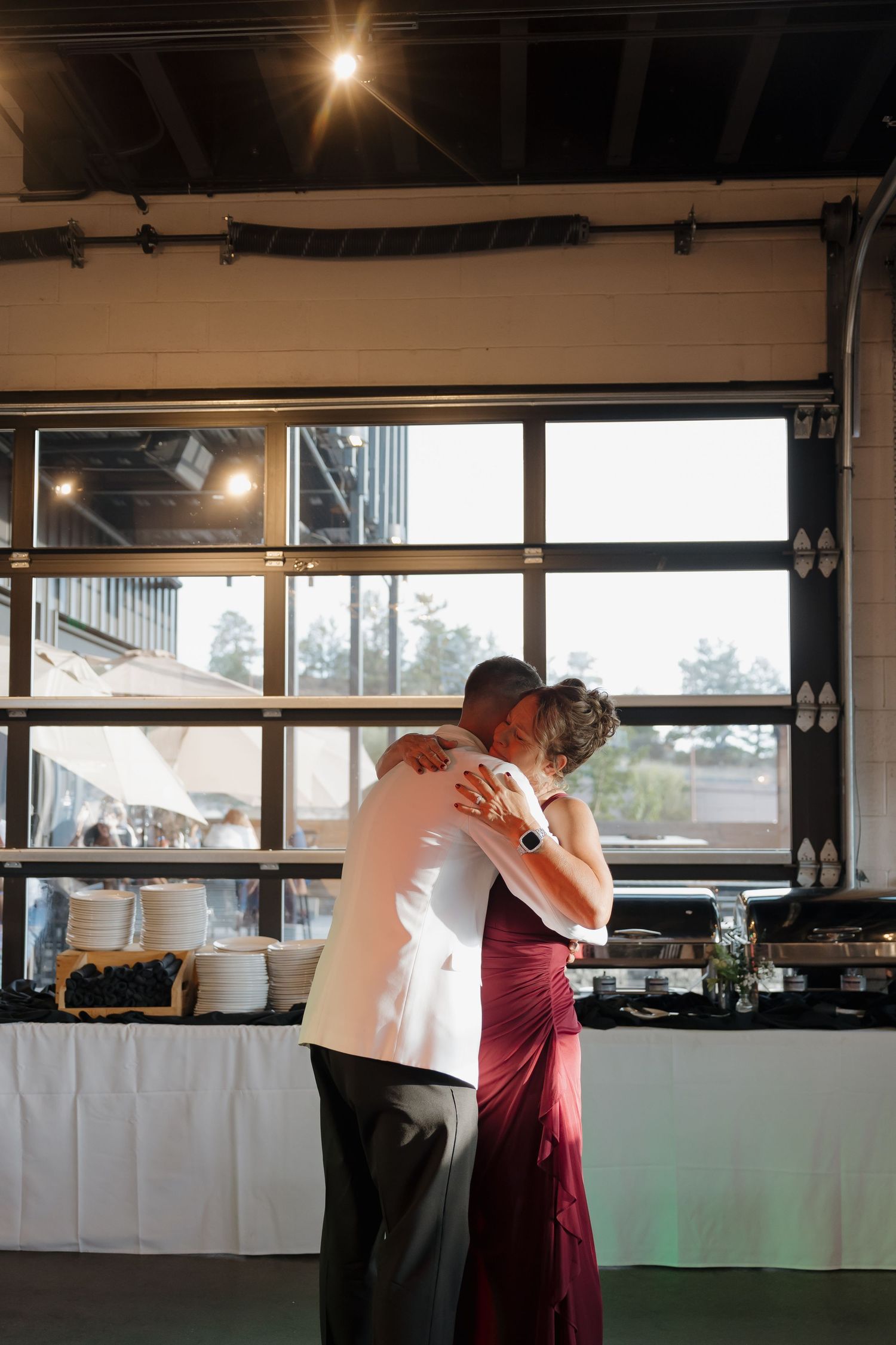 Groom and mother share an emotional embrace during their mother-son dance at the reception.