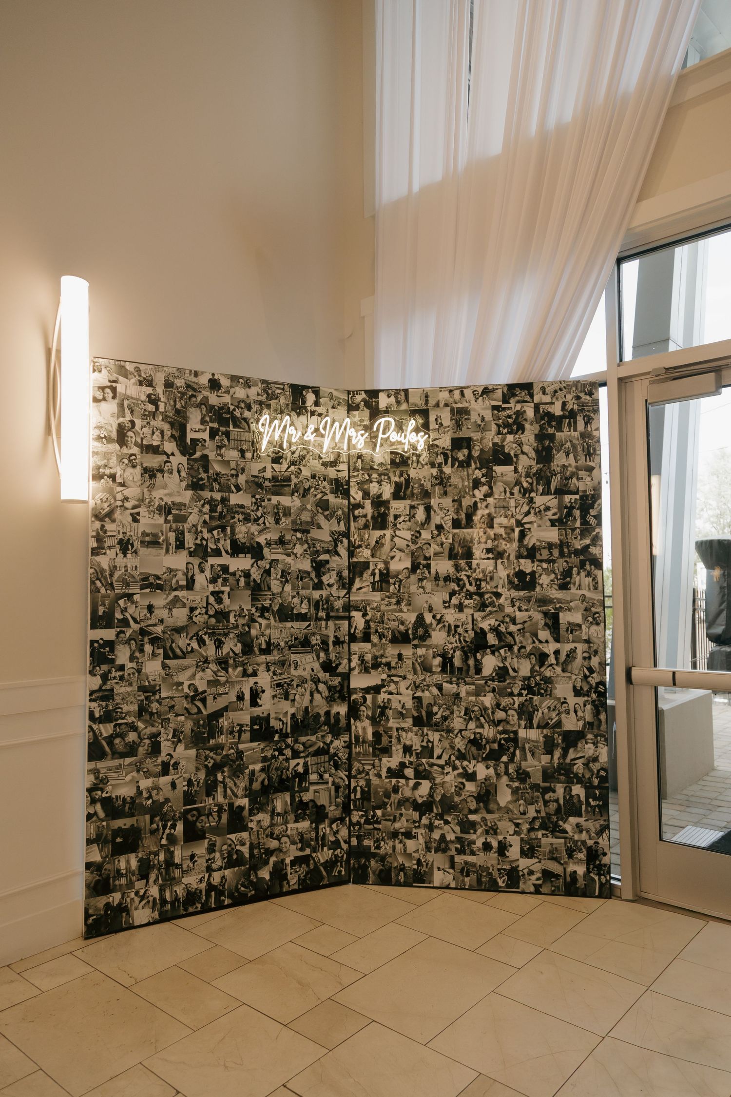 Black and white photo collage wall display with neon Mr and Mrs sign at wedding reception.