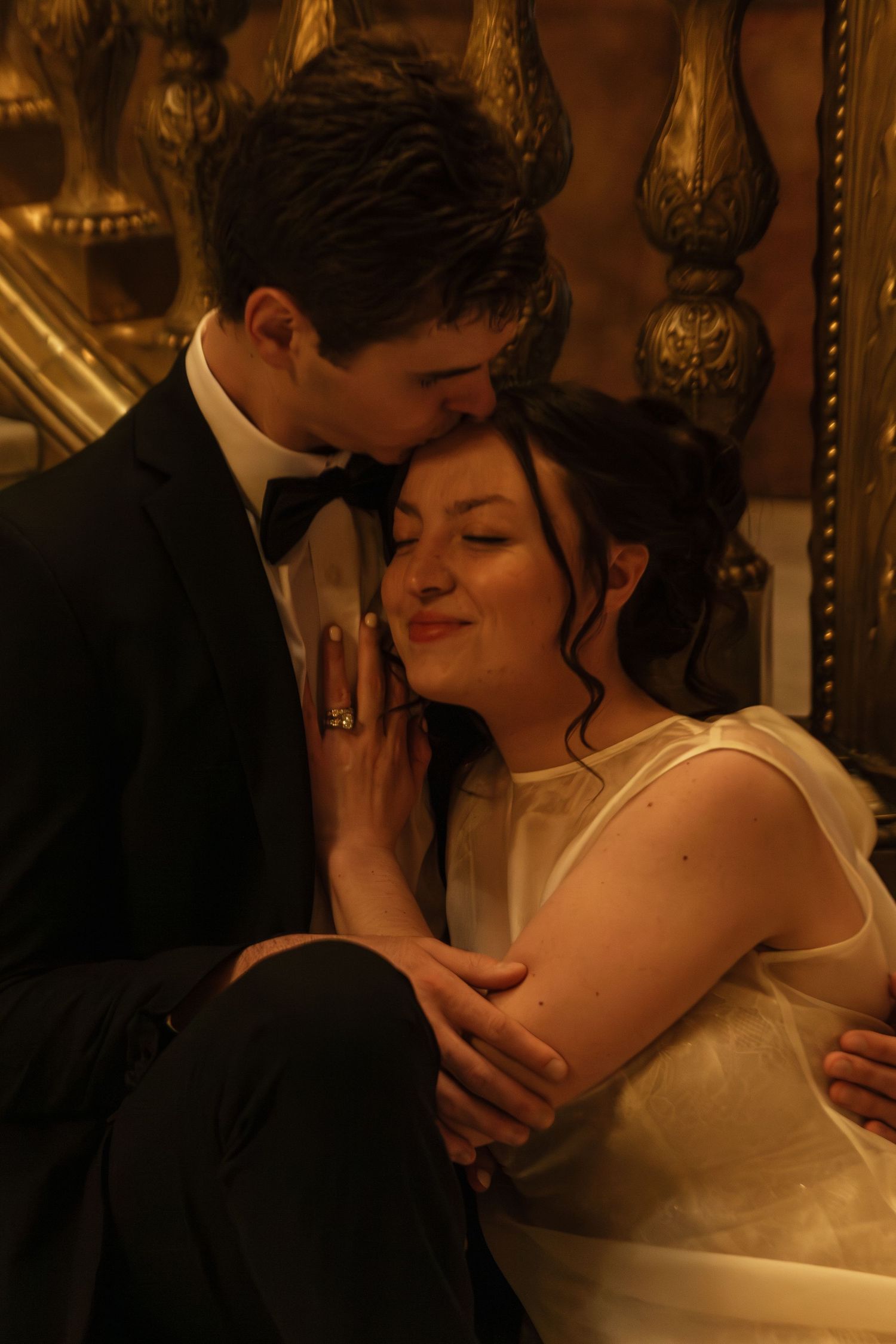Romantic couple sharing an intimate moment in a dimly lit room with ornate decor.