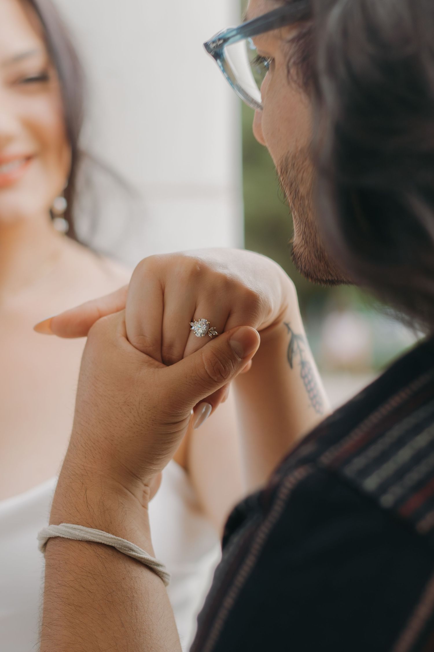 Close-up details of hands and rings in soft focus with natural lighting.