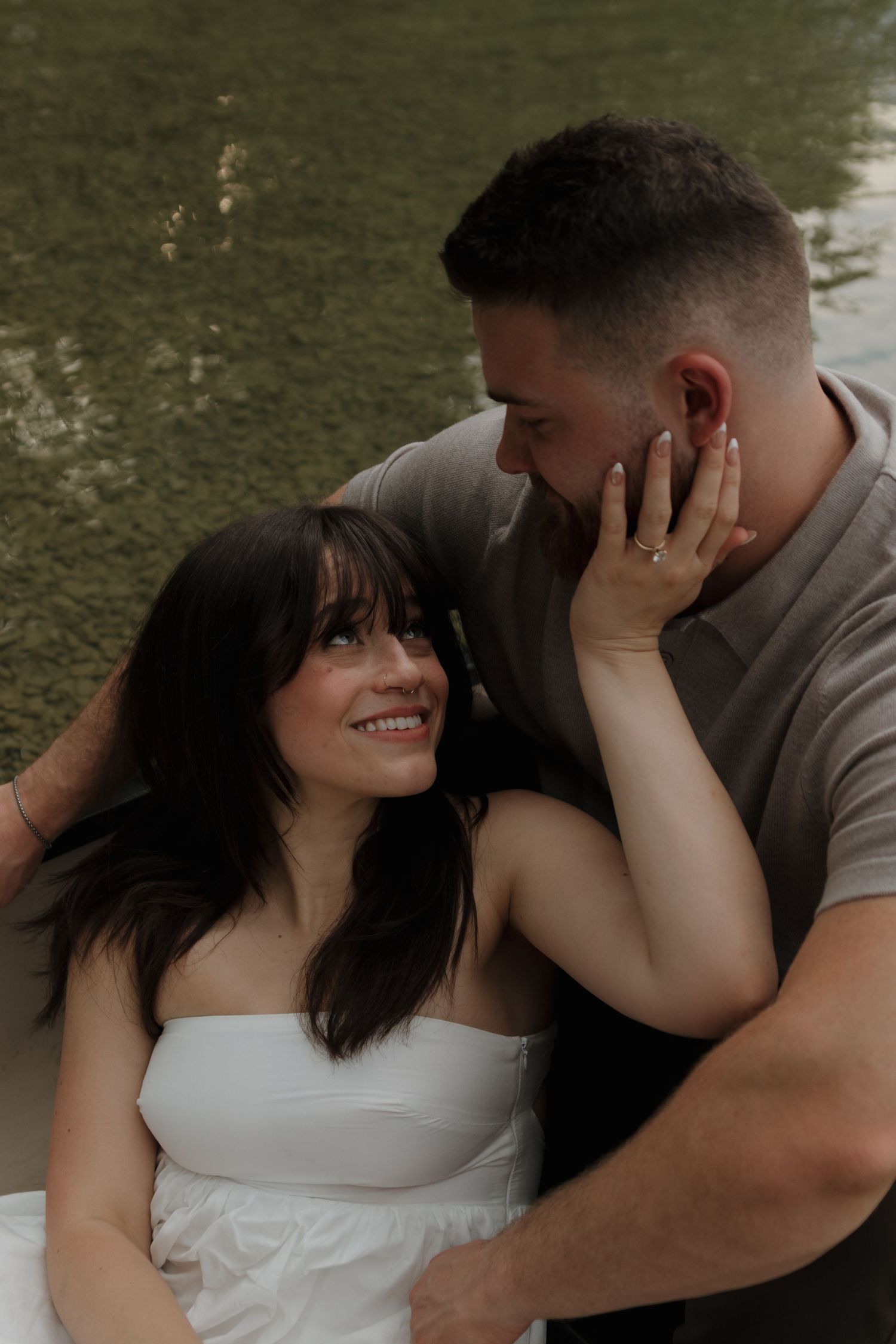 A romantic couple shares an intimate moment outdoors with soft natural lighting.
