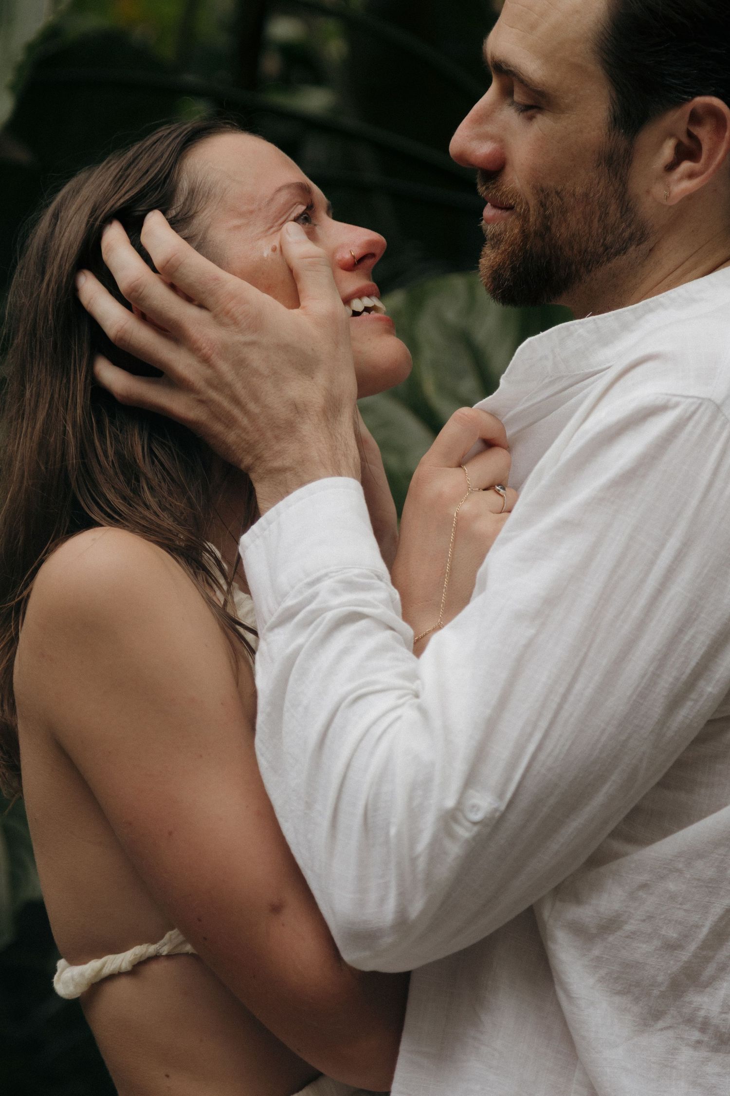 A loving couple embracing and gazing affectionately at each other in a natural outdoor setting.