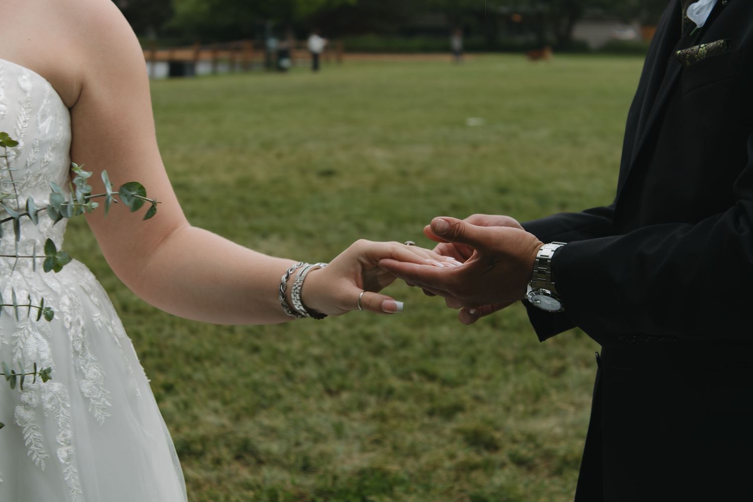 Close-up shot of hands exchanging rings during wedding ceremony.