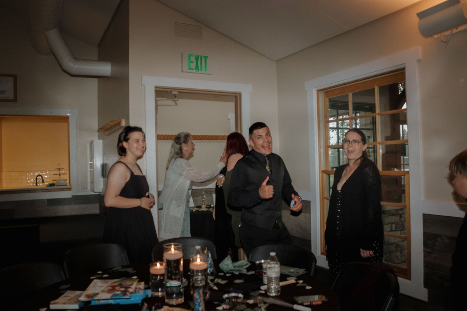 Wedding reception guests celebrating and dancing in venue room.