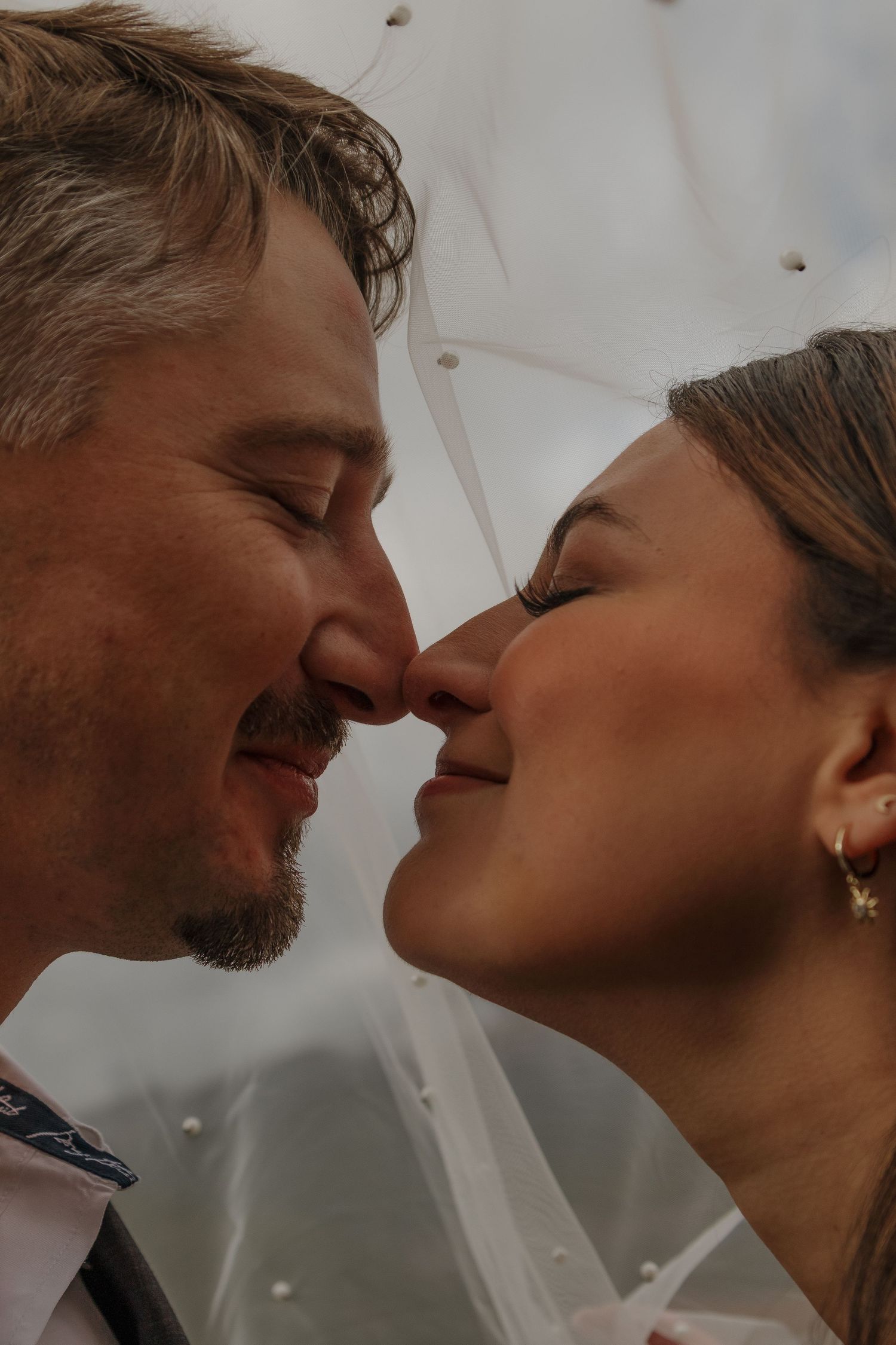 A tender close-up moment between a couple sharing an intimate kiss.