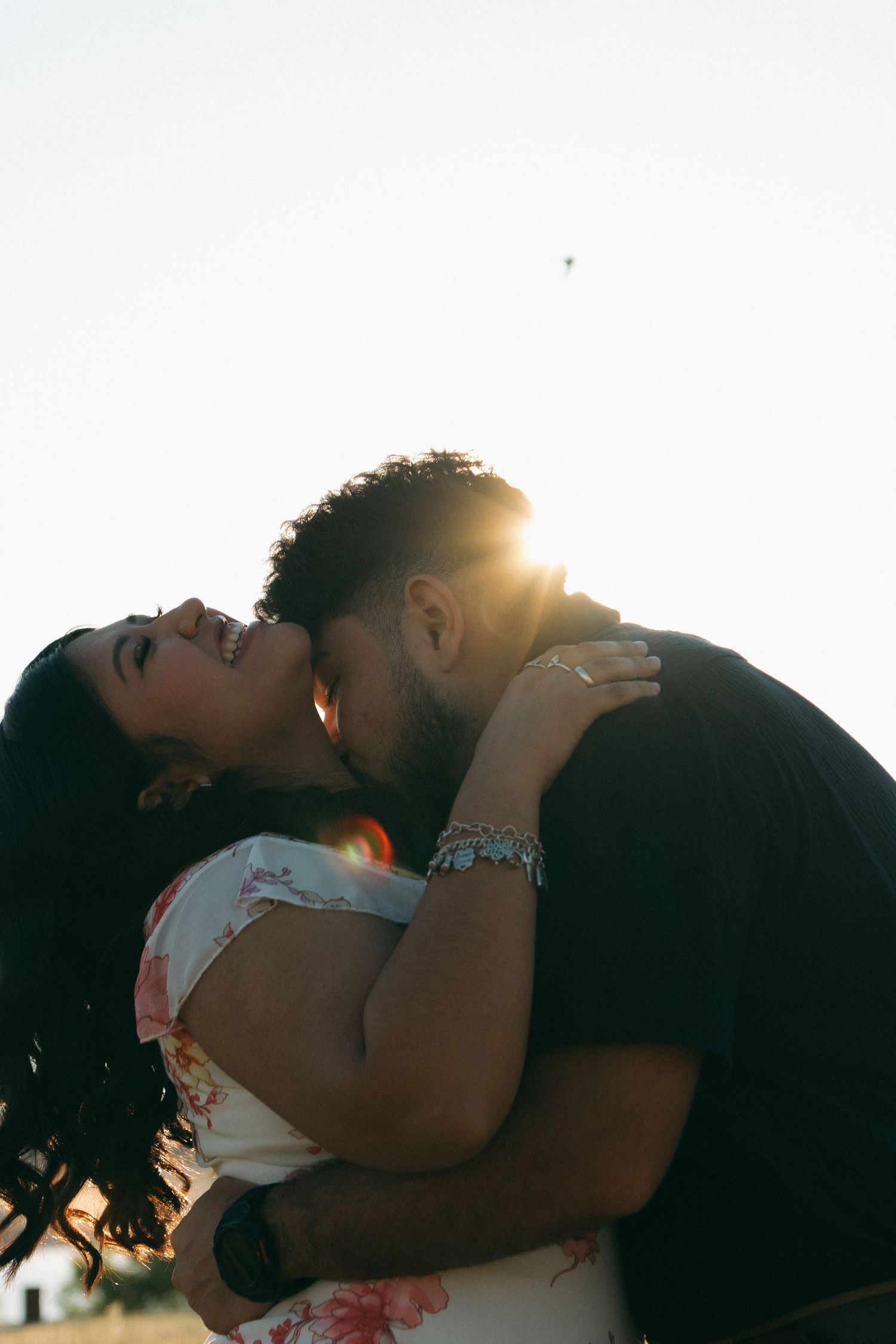 Romantic silhouettes of a couple kissing against a golden sunset backdrop.